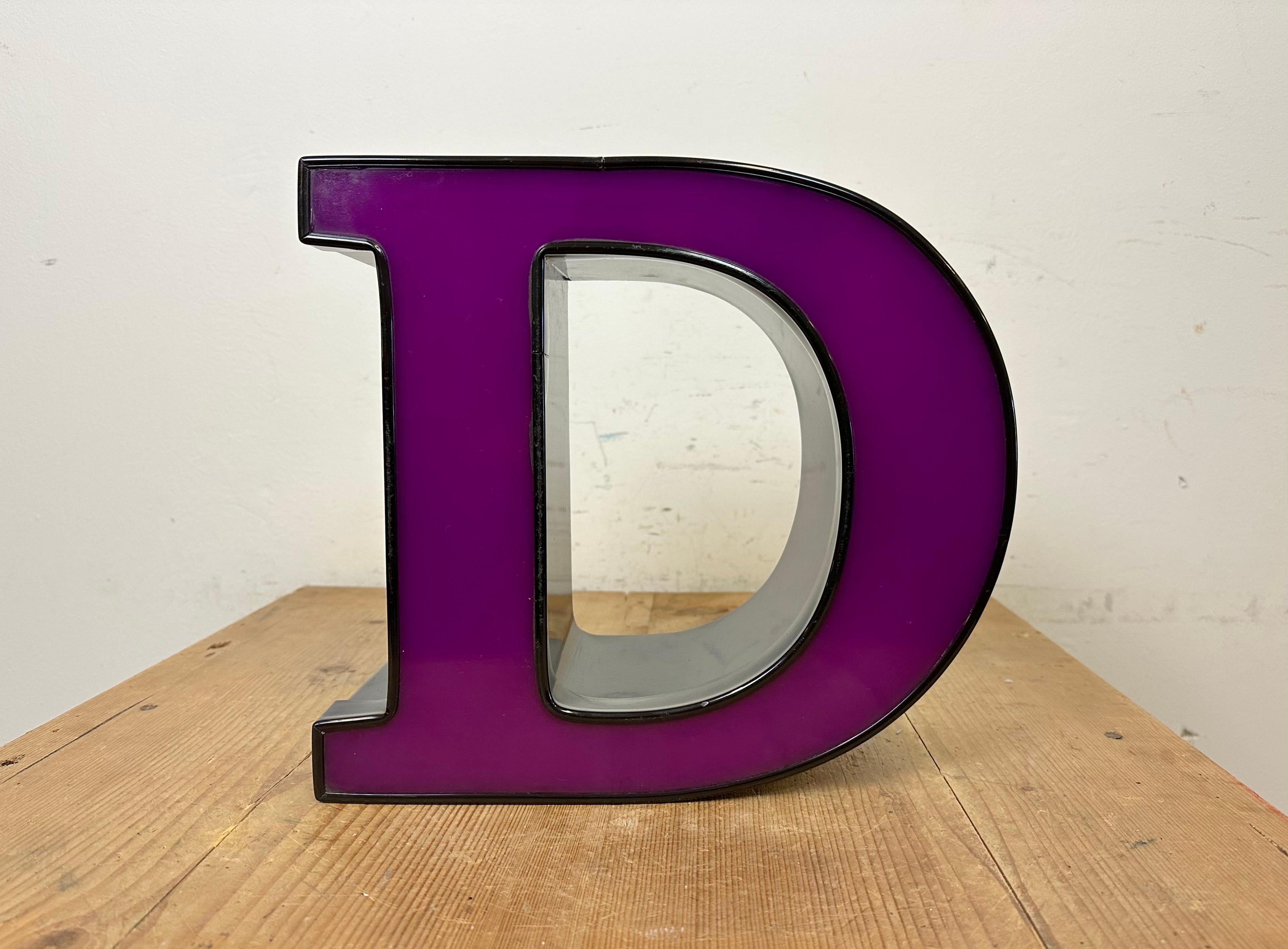 This vintage Industrial illuminated letter D was made in Italy during the 1980s and comes from an old advertising banner. It features a black metal body and a purple plexiglas cover. It is equipped with a LED strip. The letter can be used as a table