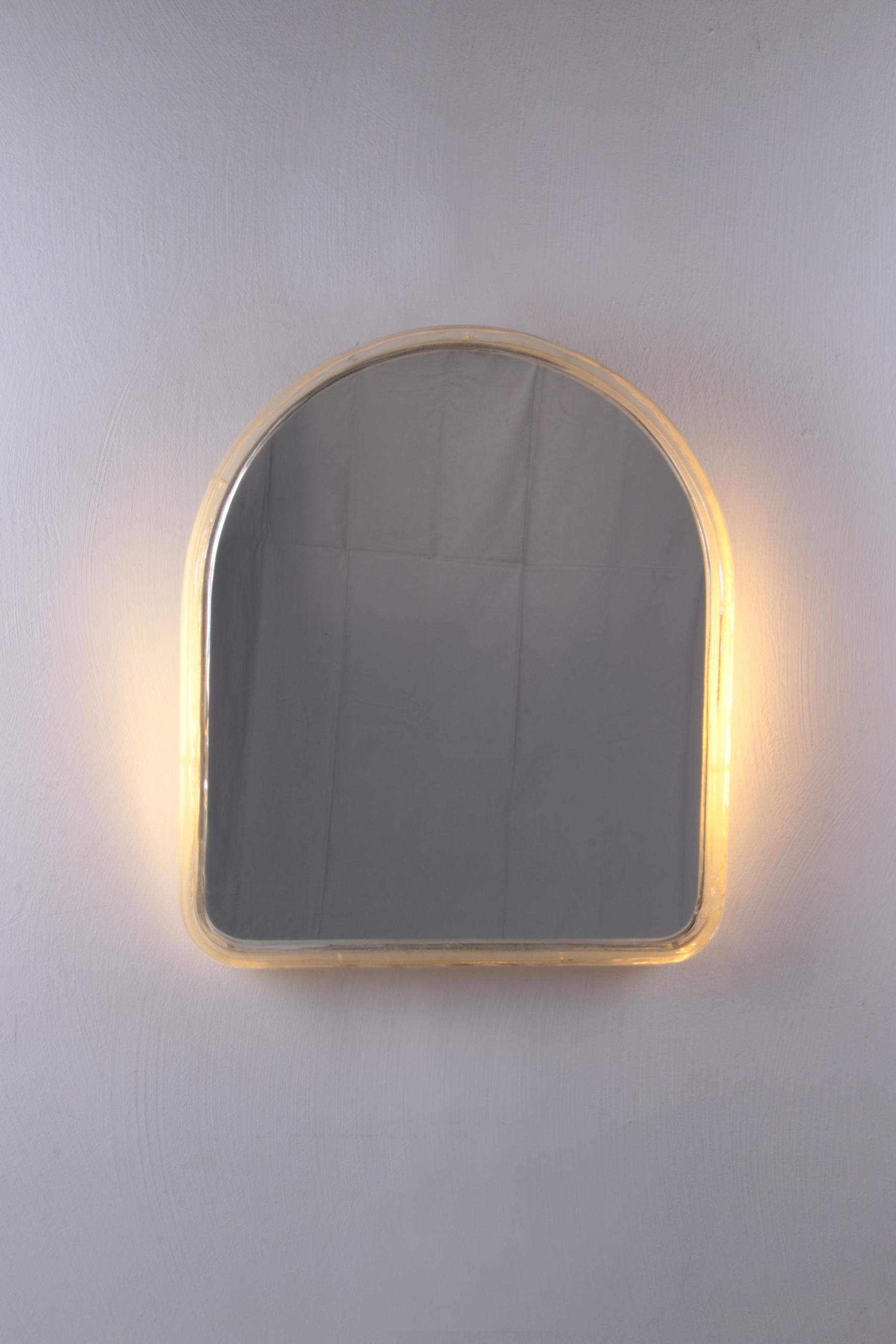 The beautiful mirror by Hillebrand is made of metal with plexiglass and was produced in the 1960s.

The shape used in this design indicates that this mirror is a rare model.

The mirror has interior lighting, which emits a warm soft light when