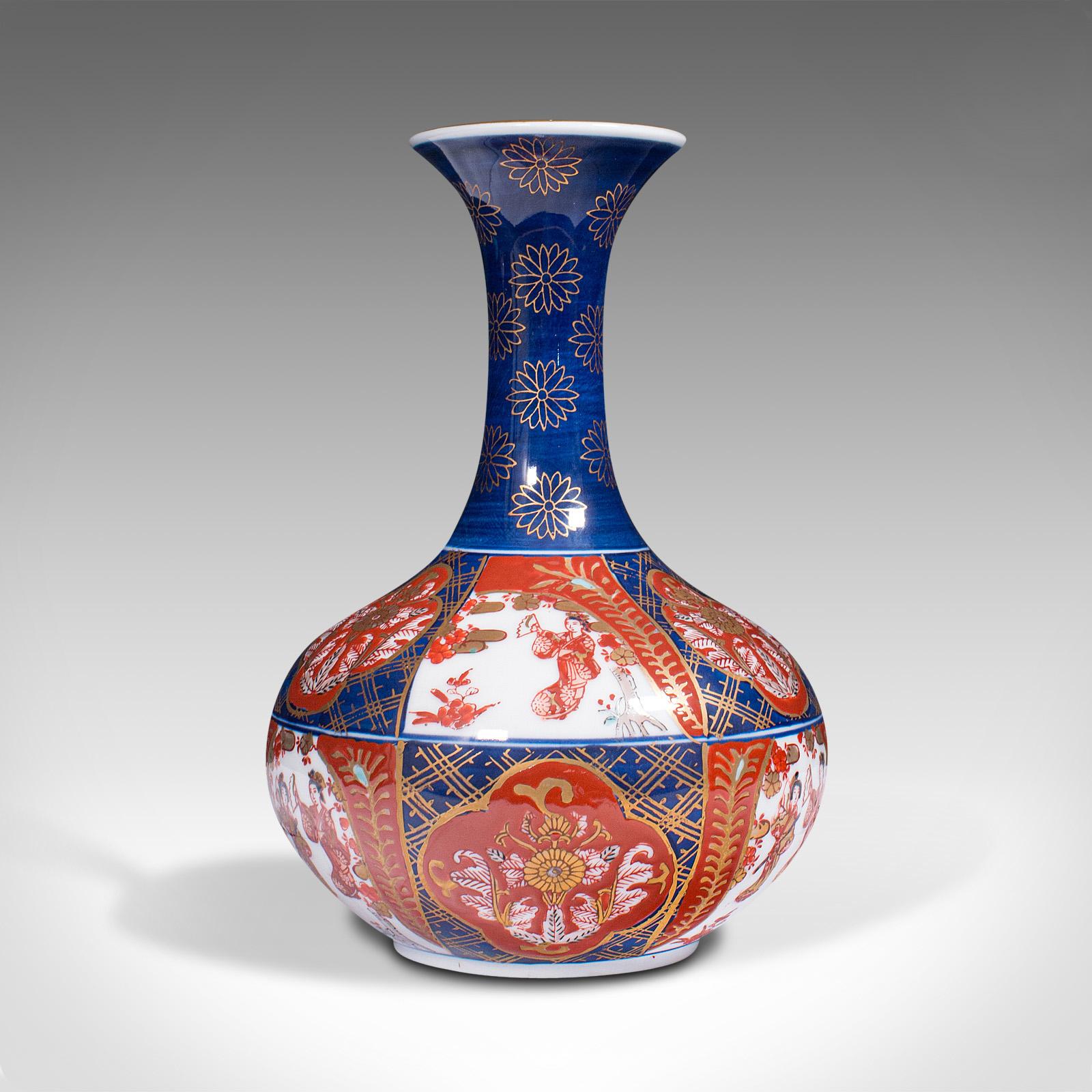 This is a vintage Imari revival flower vase. A Chinese, ceramic decorative display urn, dating to the late 20th century, circa 1980.

Vibrant red and blue palette a hallmark of the Imari taste
Displaying a desirable aged patina