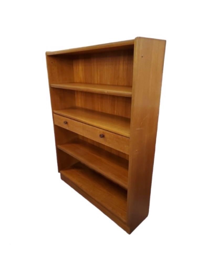 Mid 20th century teak bookcase/display cabinet. It has two central drawers that open and close with ease, and an adjustable shelf above and one underneath.