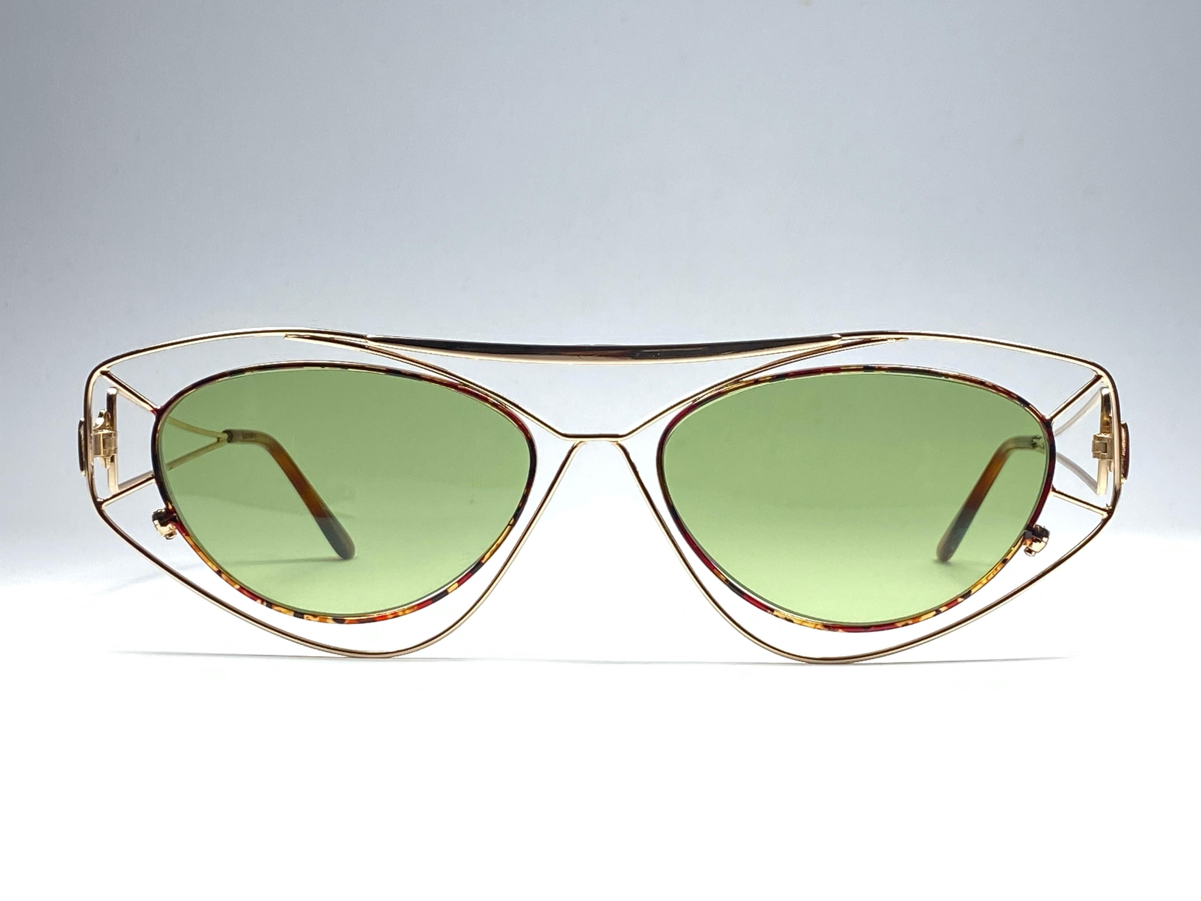 New Vintage in the style of Paloma Picasso gold with tortoise inserts sunglasses. 
Light green lenses.
Made in  1980's. 

Frame with minor wear and tarnish due to storage. 

Front : 15 cms

Lens Height : 4 cms

Lens Width : 5 cms
