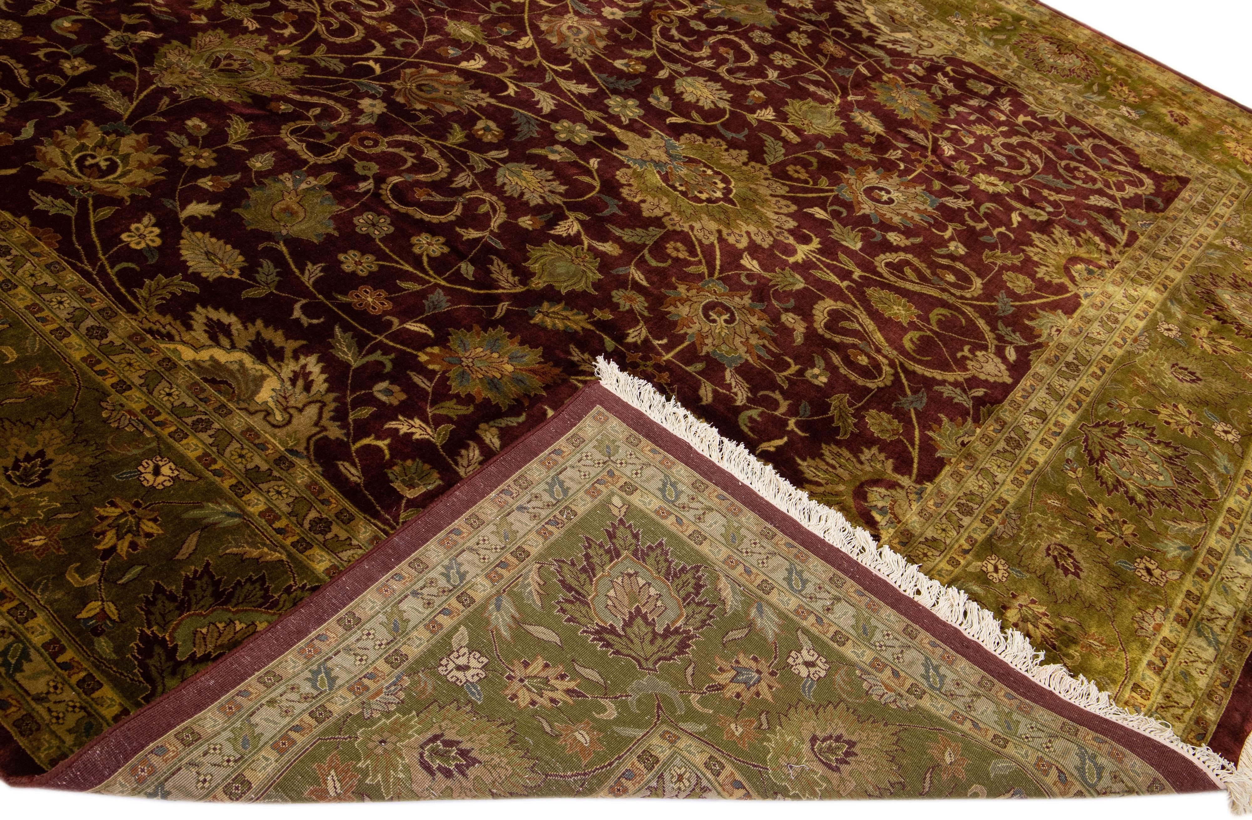 Magnifique tapis antique Agra en laine nouée à la main avec un champ bordeaux. Ce tapis indien a un cadre vert avec des accents multicolores dans un magnifique motif floral.

Ce tapis mesure : 12' x 17'9''.