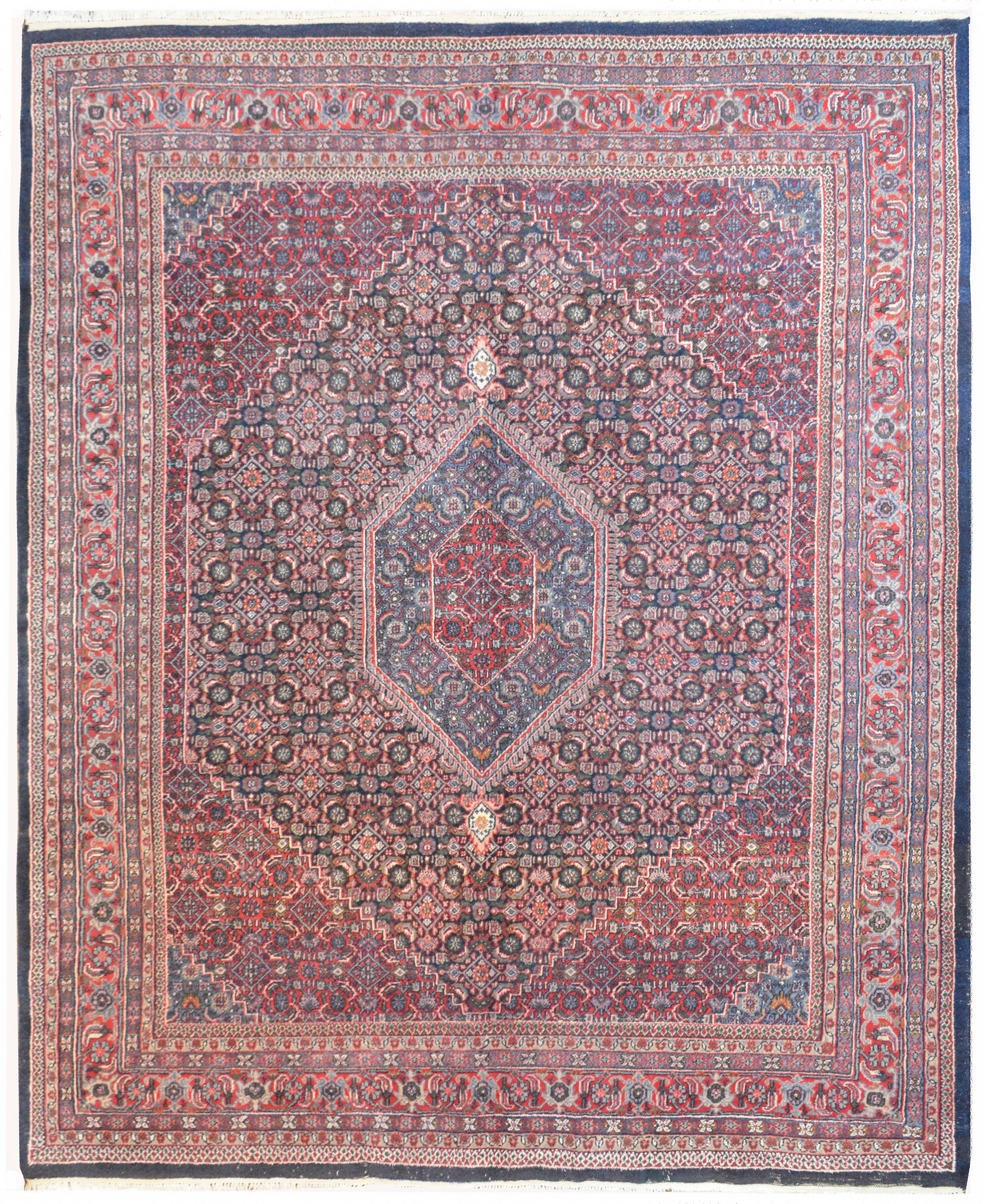 A vintage Indian hand knotted Bidjar rug with multiple floral trellis patterns woven in crimson, pink, white, indigo, green, and gold vegetable dyed wool. The border is composed of multiple thin floral patterned stripes.