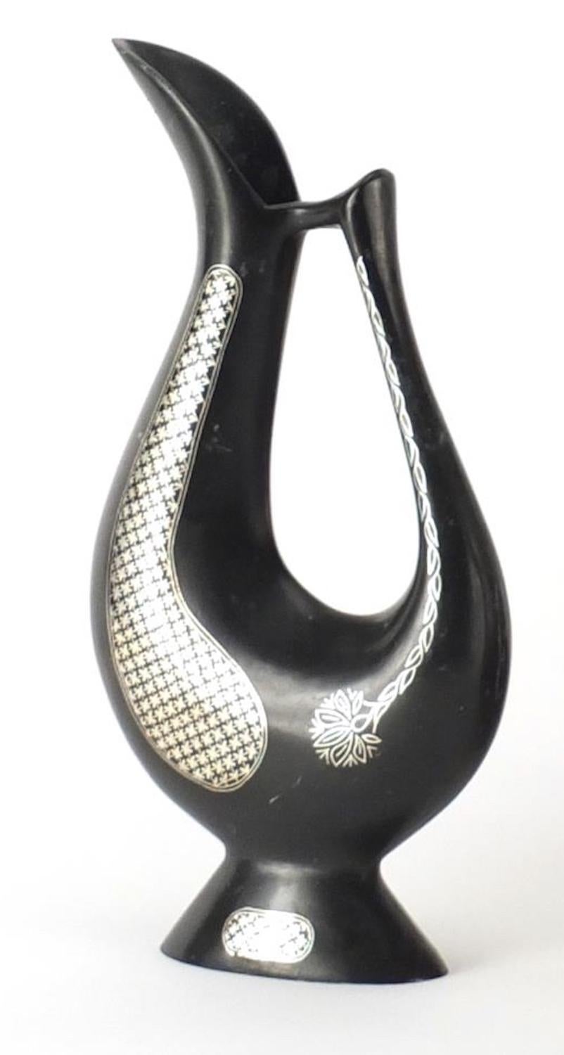 L'aiguière indienne en Bidriware est un objet décoratif original réalisé à la fin du 20ème siècle par une manufacture indienne. 

Cette œuvre d'art est décorée d'une incrustation argentée.

Ce bel et très précieux objet décoratif a été réalisé