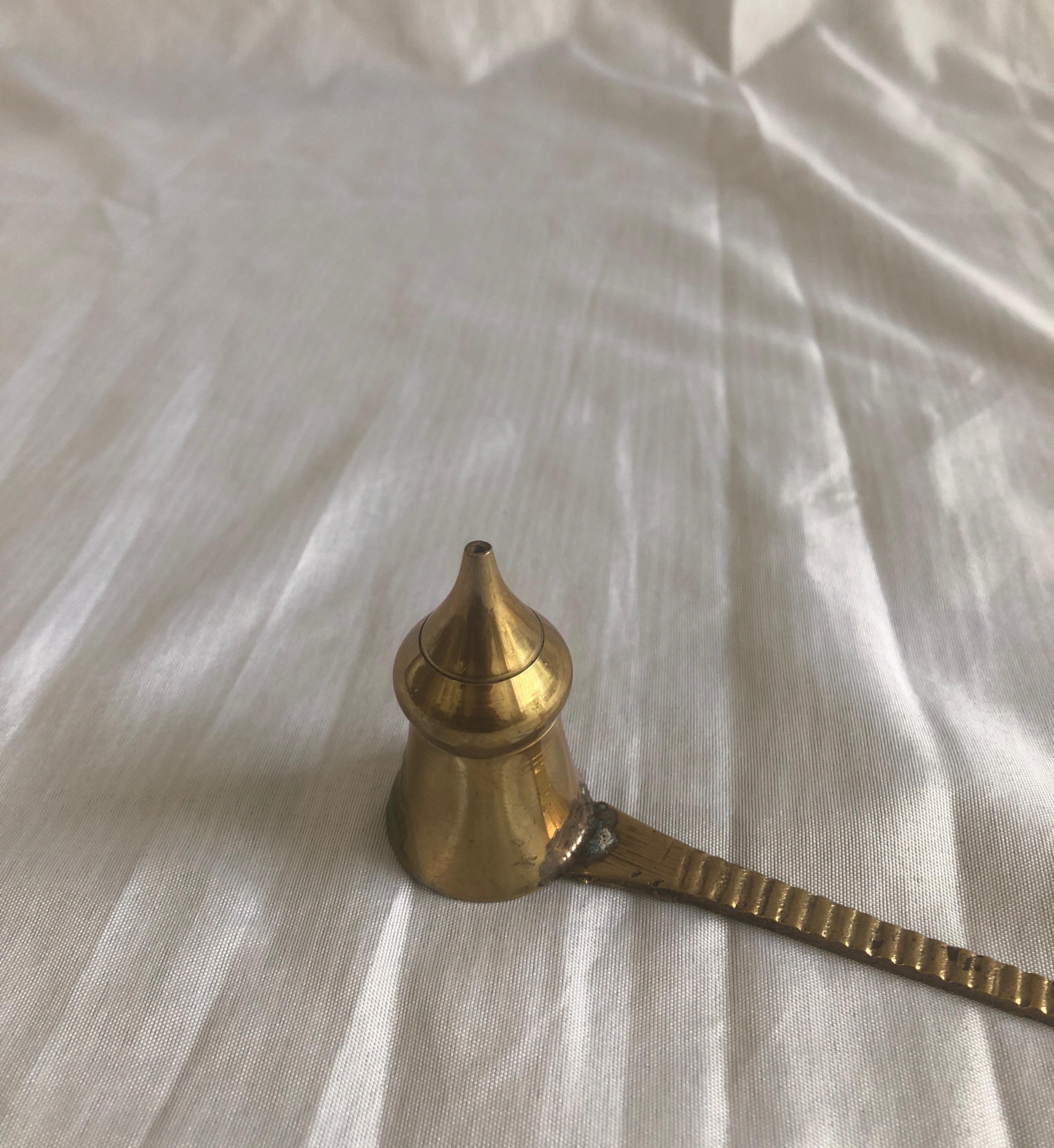 Vintage Indian brass candle snuffer.
Conical shape snuffer with ribbed arm and rounded handle.
Size: 9” L x 2.5” H x 1.5” D.