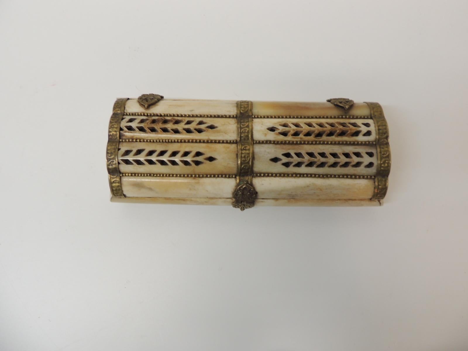 Vieille boîte à bijoux indienne en os de chameau
Forme rectangulaire avec détails en laiton martelé à la main. Le couvercle est orné de motifs de feuilles percées et de perles en laiton insérées entre les os. Boîte à bijoux vintage doublée de