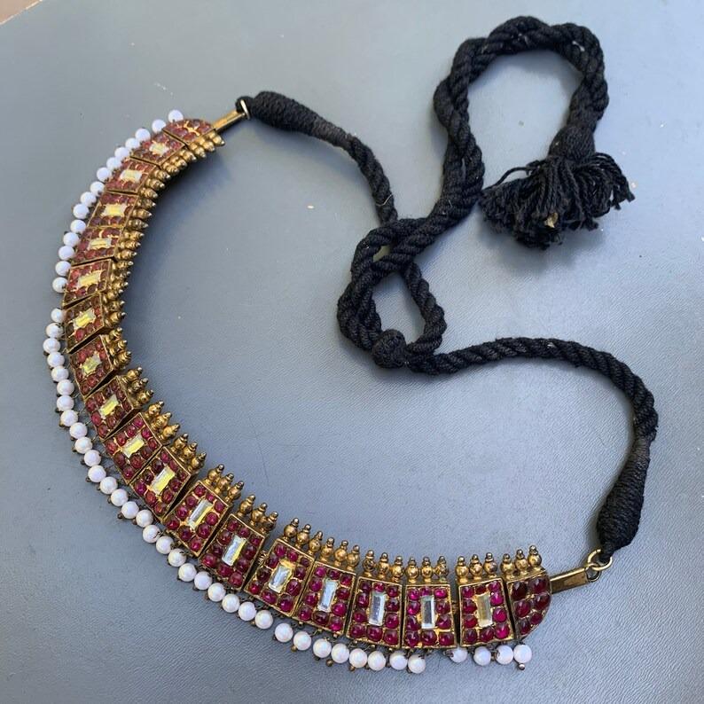 Old wedding  handcrafted choker necklace hails from Sri Lanka or South India and showcases exquisite craftsmanship. Made from gold-gilt silver, the necklace features 19 beautifully crafted closed-back panels, each set with foiled-back gemstones that