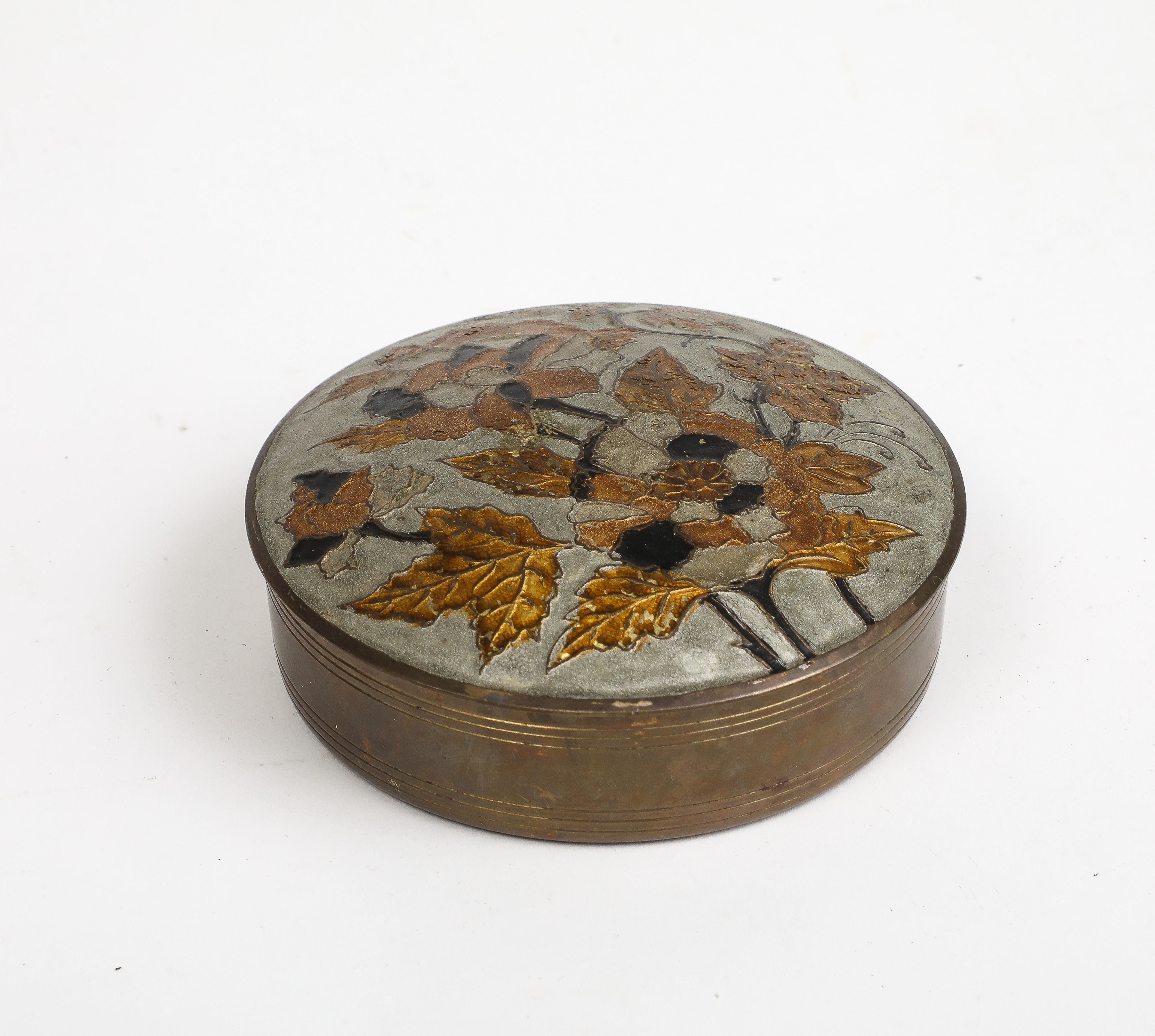 Vintage cloisonné round trinket box, with black and gold flower and foliage decorating the lid. Made in India sticker on bottom. 