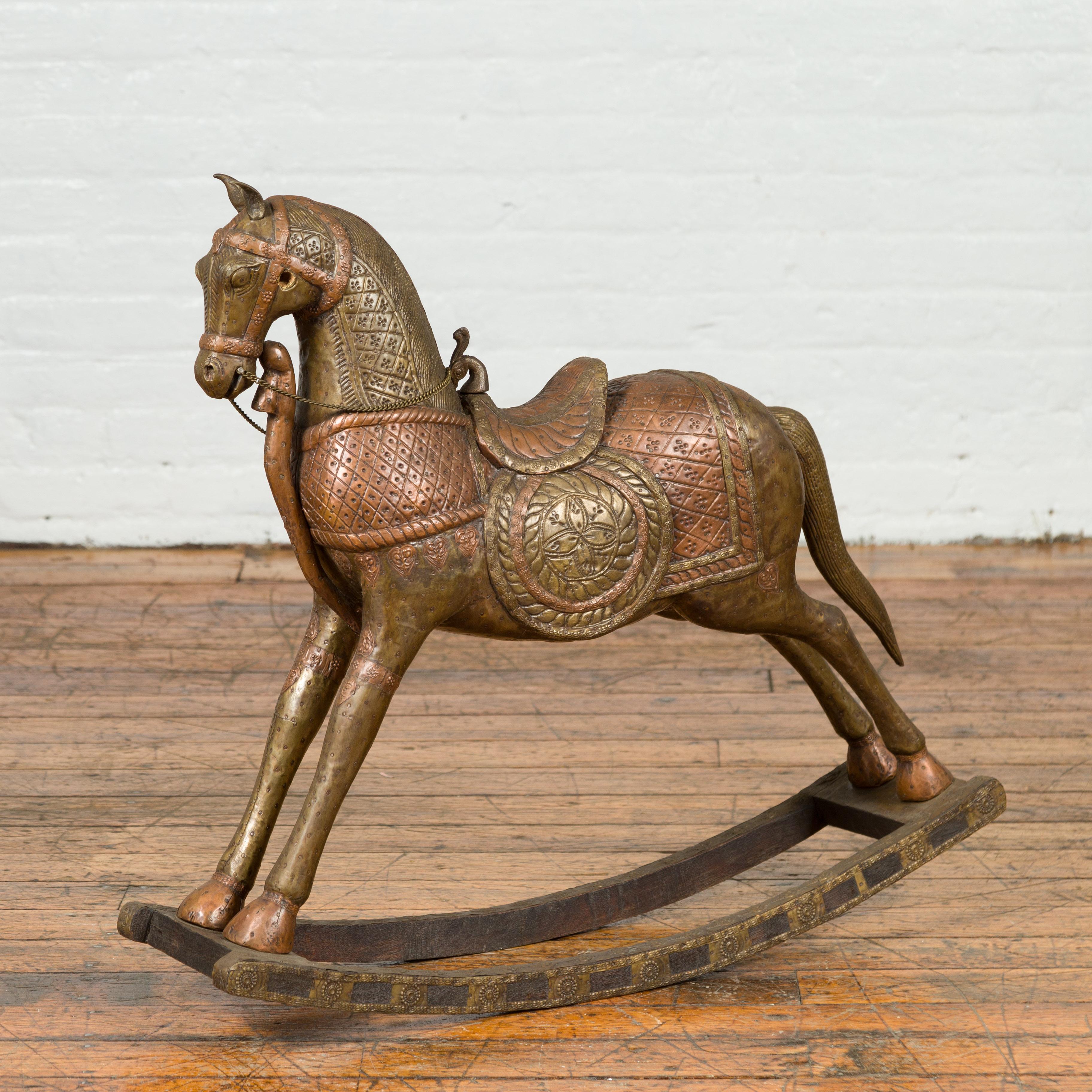 An Indian vintage two-toned rocking horse from Madras from the mid-20th century, made of copper over wood. Born in the Indian state of Tamil Nadu during the midcentury period, this copper over wood rocking horse charms us with its petite proportions