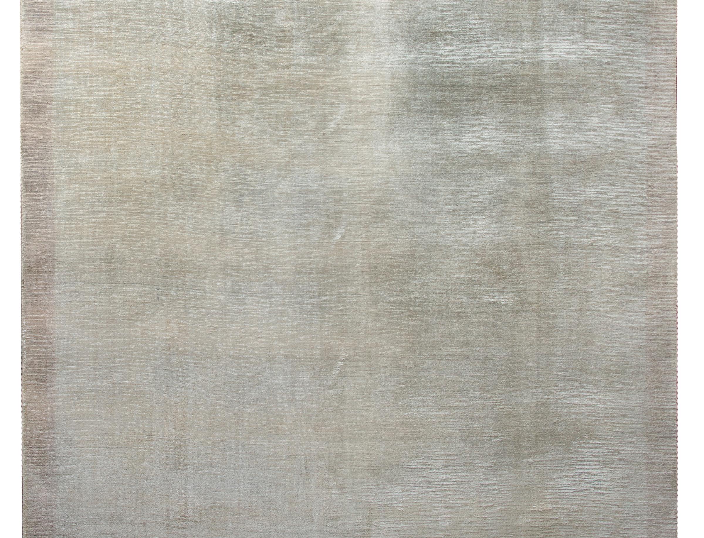 A stunning and chic late 20th century Indian Gabbeh-style hand knotted silver silk rug woven with a cut and loop pattern across the field.