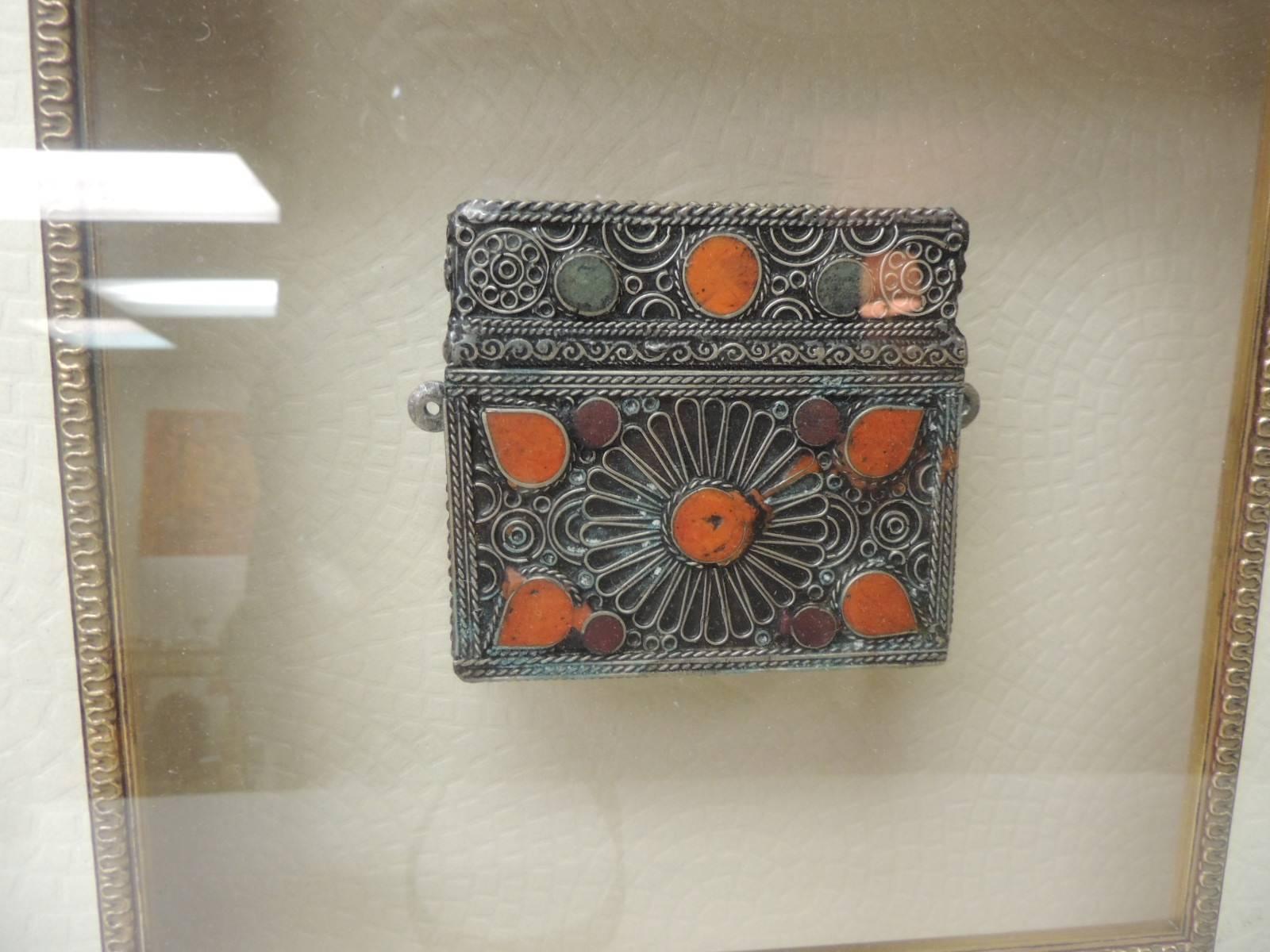 Vintage Indian metal purse mounted on shadow box with wood frame
Antique silver small vintage Indian purse with intricate detailing including enamel details to look like coral. Framed in a new wood gold leaf shadow box style. In shades of gold,