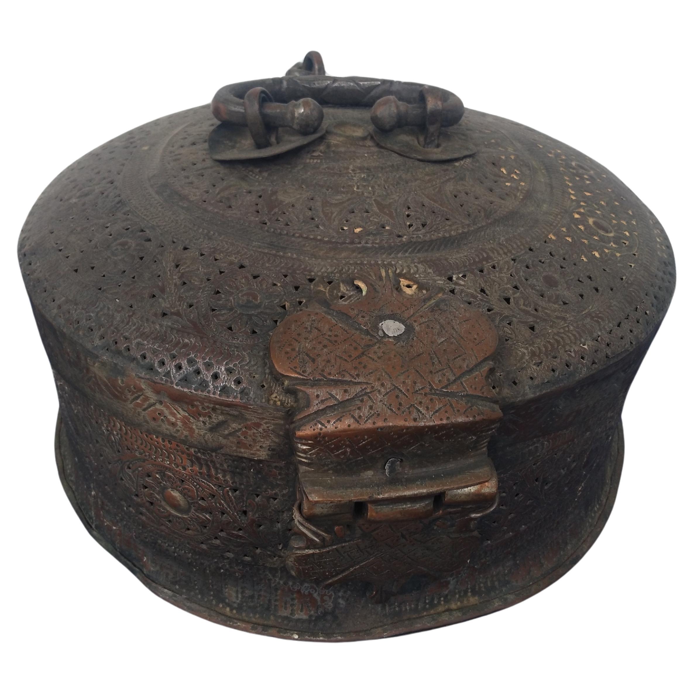 Cette boîte de conserve est une œuvre d'art étonnante. Appelé Pan Daen Mughai, il est originaire d'Inde. Il est fabriqué dans un métal semblable au cuivre et présente un motif percé. La poignée et les loquets sont en acier forgé à la main. 

Un bel