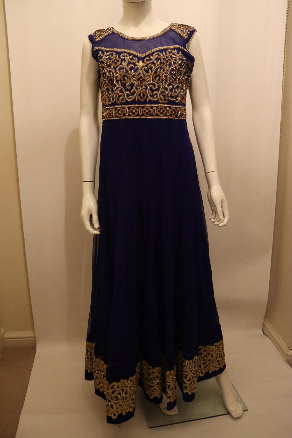 A head turning Indian party dress with wonderful embroidery detail. The dress is in a vibrant blue colour , and is sleaveless with a scoop back and side zip opening. It has layers of underskirt and heavy gold embroidery at the hem ,neckline and