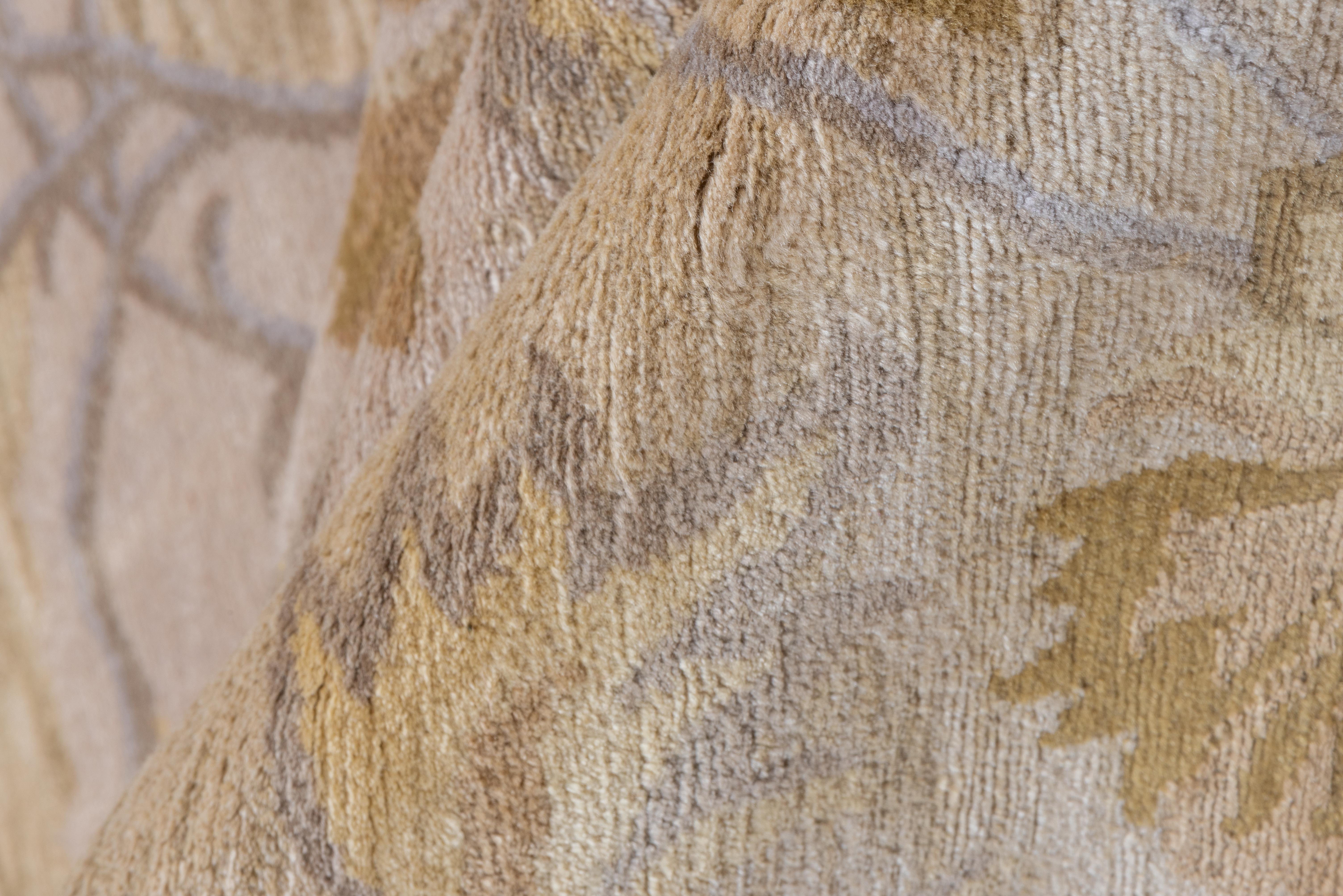 This vintage Indian rug presents a refined botanical arrangement across a creamy ivory field, where delicate scrolling vines and stylized blossoms bloom in tones of sand, wheat, and muted taupe. The composition is both graceful and symmetrical,