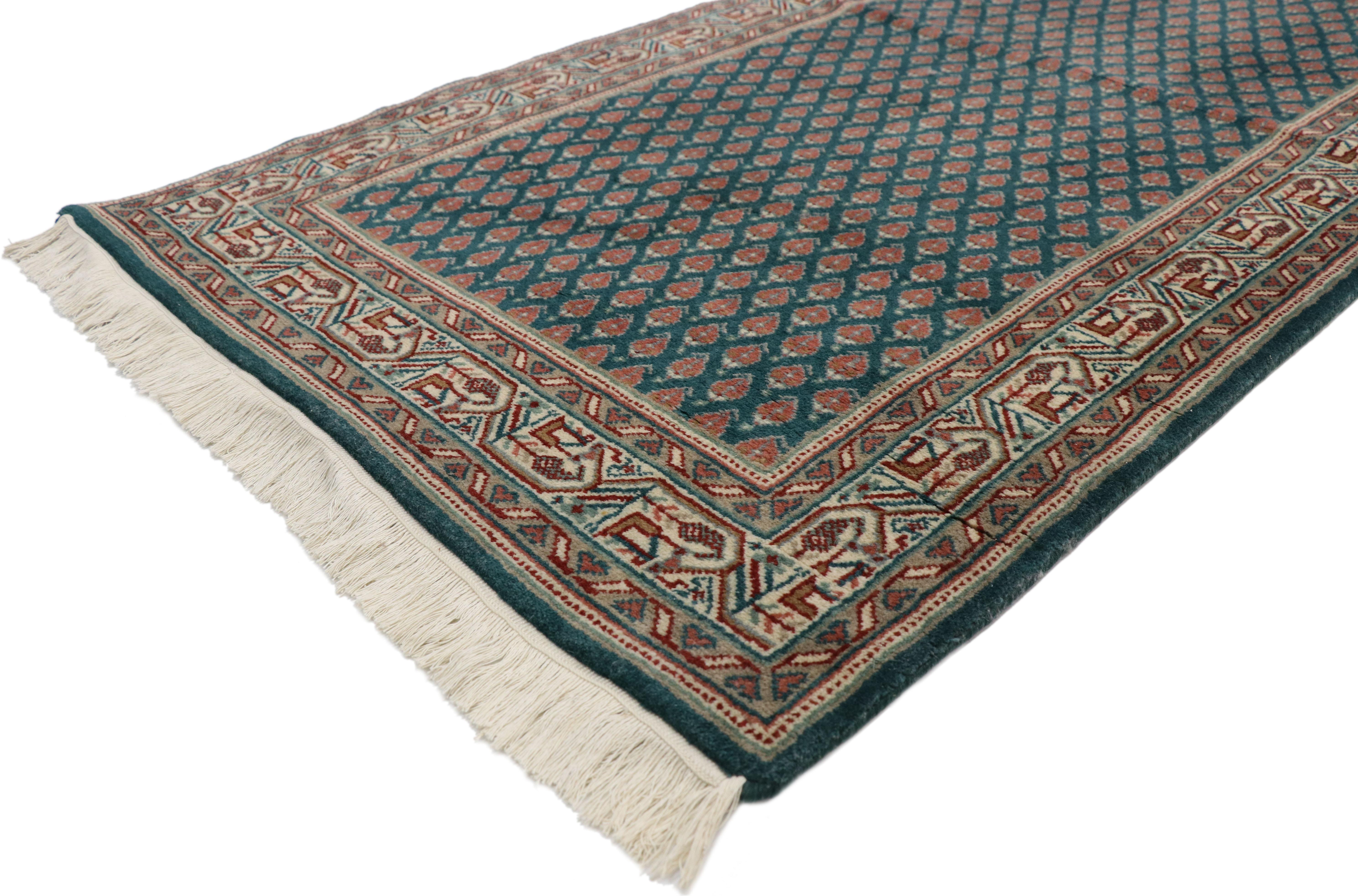 72083, vintage Indian runner with Old World Victorian style. This hand knotted wool vintage Indian runner displays an all-over repetitive pattern of opulent boteh motifs. The widely used boteh motif is thought to symbolize life with its resemblance