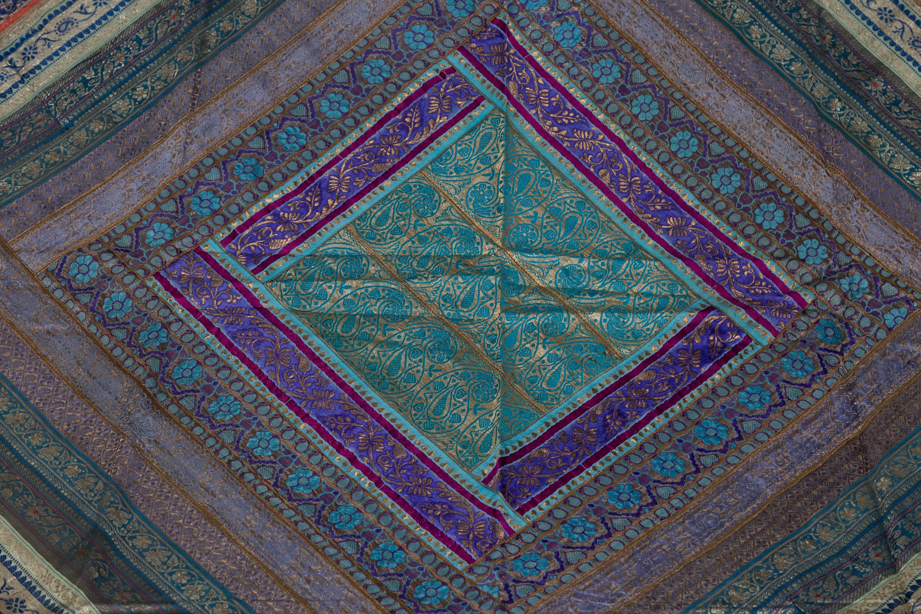 An Indian vintage large silk embroidered fabric from the second half of the 20th century with turquoise, violet, purple, green and gold tones among others. Possibly originating from Rajasthan, this stunning silk fabric is made of sari pieces that