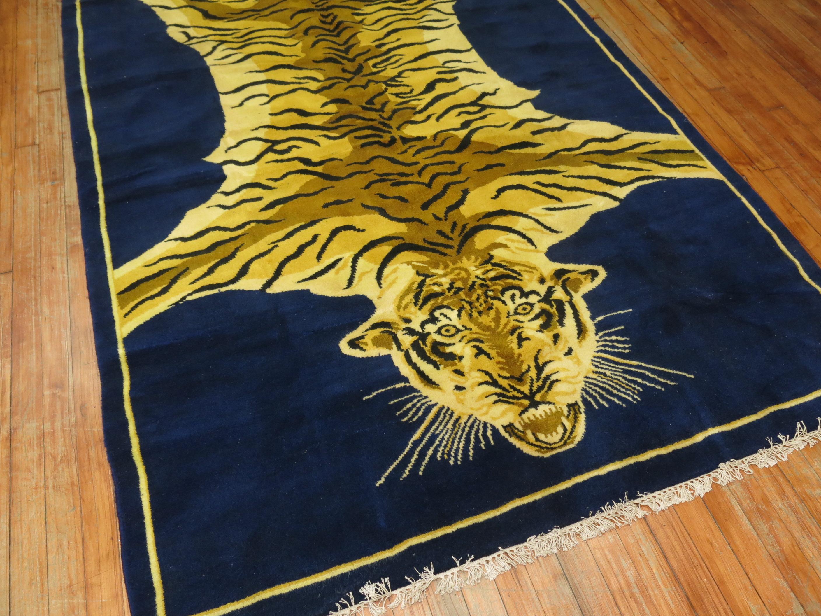 A late 20th century Indian Rug with a large tiger flanked on a deep royal blue field.

