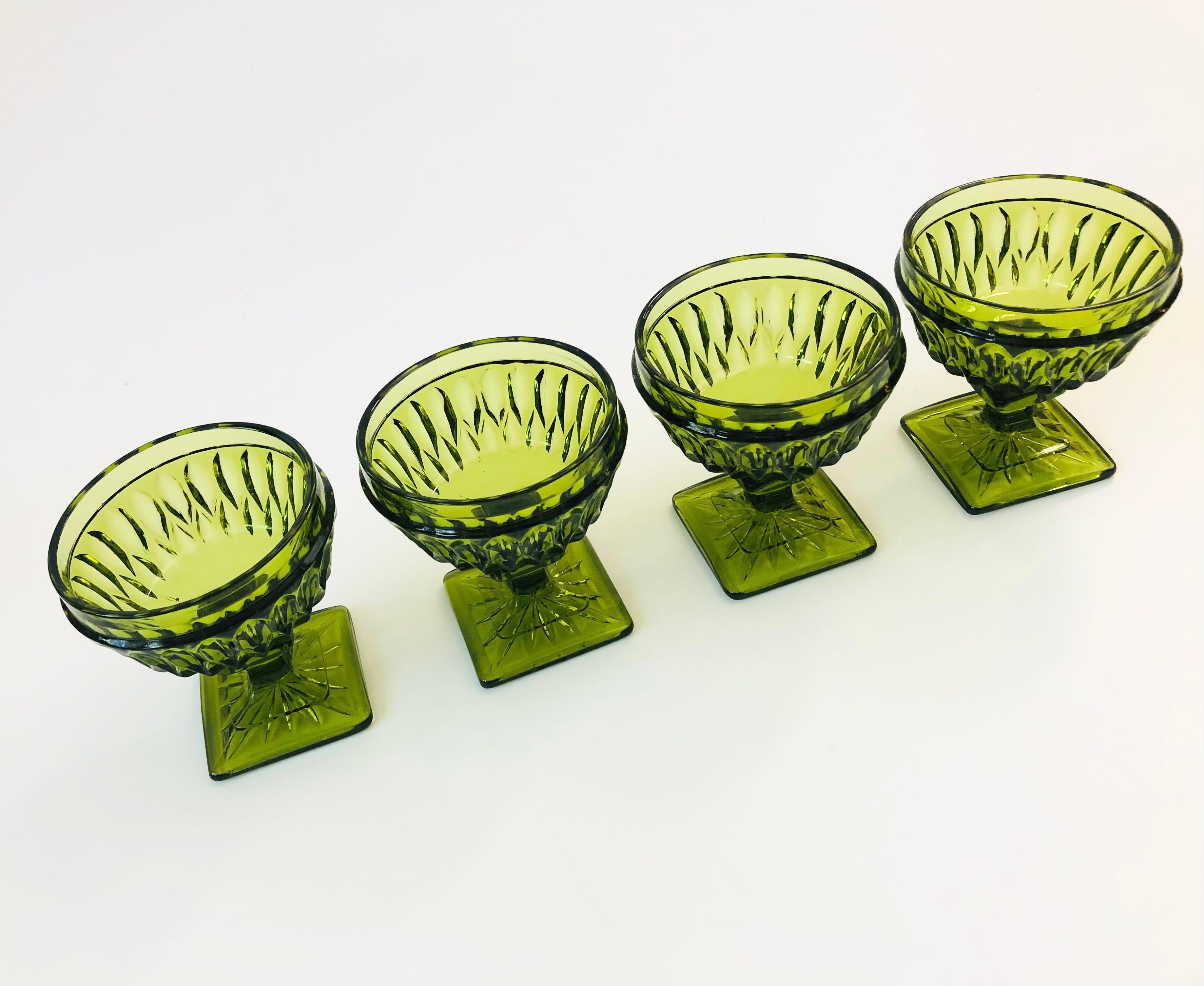 A set of 4 gorgeous coupe glasses with a lovely ornate design in dark green glass. Made in the Mt Vernon pattern by Indiana Glass.
    