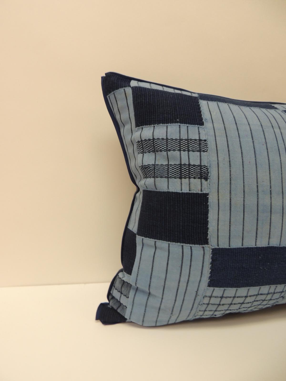 Vintage indigo and blue African woven and embroidered checkerboard pattern decorative lumbar pillow. Throw pillow handcrafted with a vintage textile from the artisanal fiber arts traditions of Africa. Decorative lumbar pillow finished with navy blue