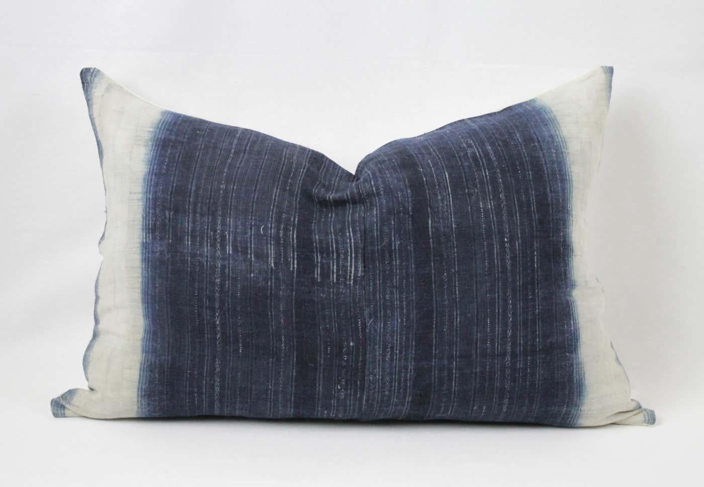 Vintage vertical indigo blue and white batik style pillow, with zipper closure. Back is in a natural antique French linen. Pillow is darkest in the center and then fades out to an off-white. Main colors are indigo blue, off-white, medium blue, and