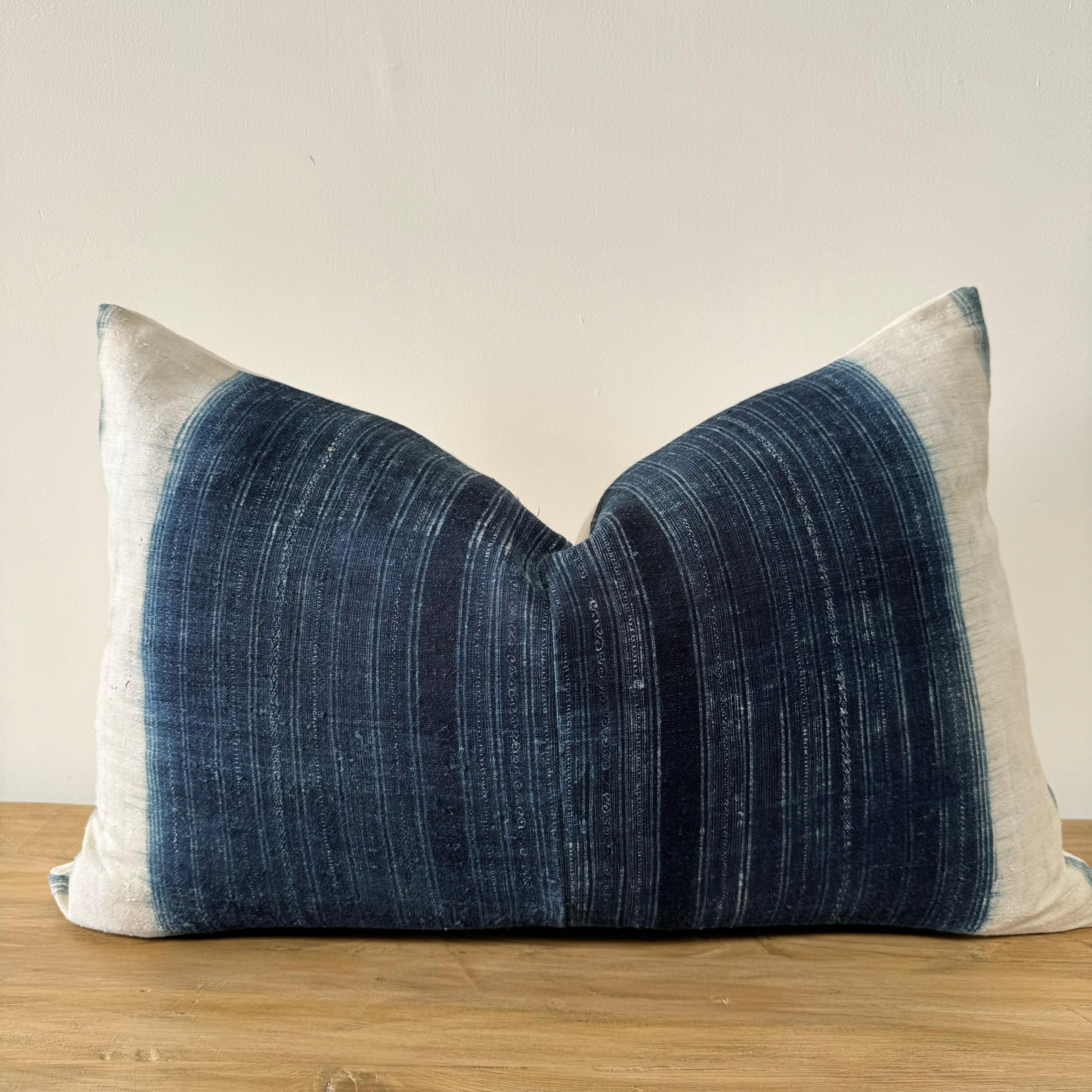 Coussin vintage vertical bleu indigo et blanc de style batik, avec fermeture à glissière. Le dos est en lin français antique naturel. L'oreiller est le plus foncé au centre et s'estompe ensuite pour devenir blanc cassé. Les couleurs principales sont