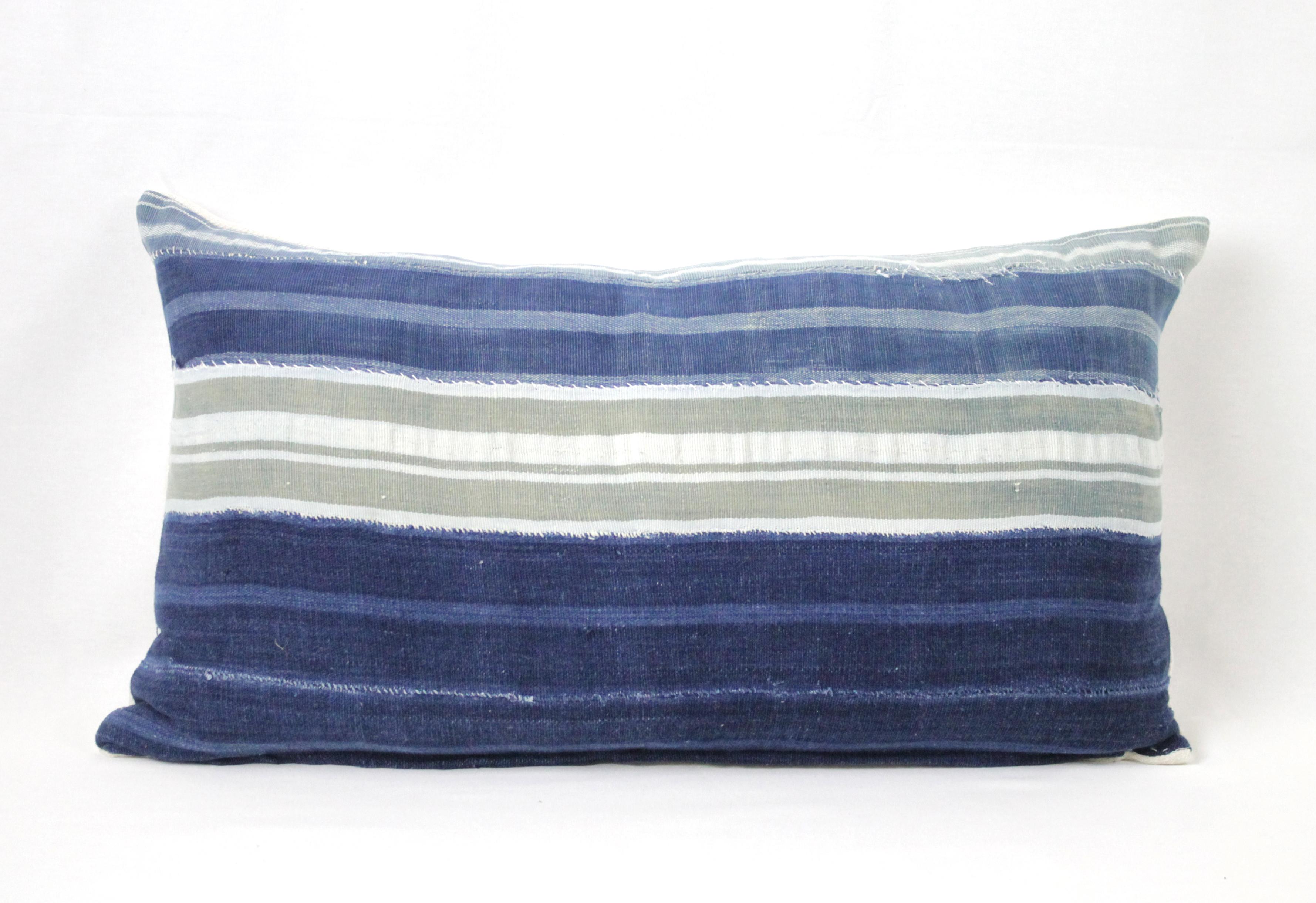 Vintage batik indigo blue, tan and grey or green batik style pillow, with zipper closure. Back is in a natural antique grain sack linen. Pillow has horizontal stripes with exposed seams. Main colors are indigo blue, light blue, tan, and grey or