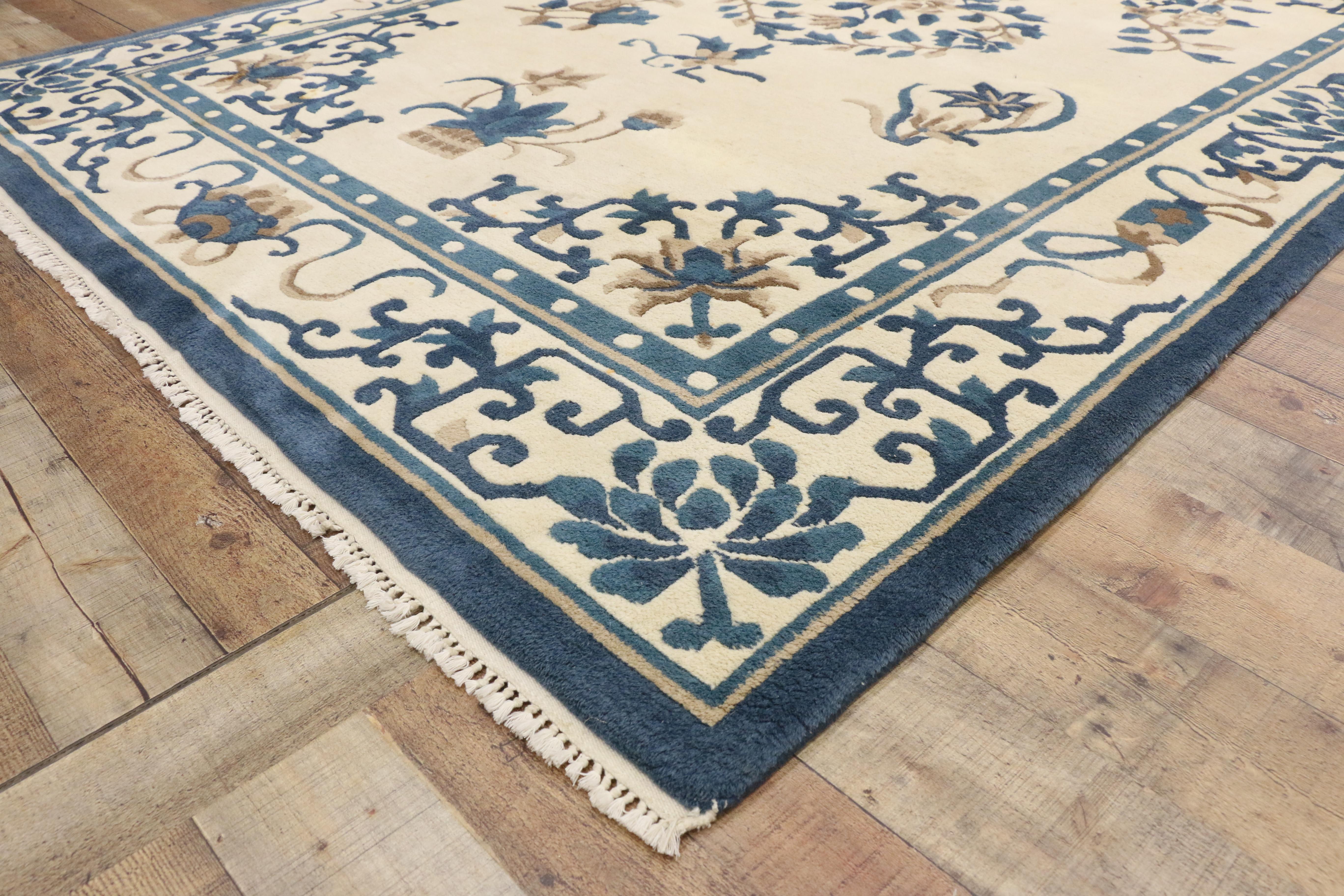 77211, Vintage Chinese Peking Chinoiserie Style Rug. This hand knotted wool vintage Chinese style rug features a rounded open centre medallion comprised of interlaced peony blossoms and vinery. Floral motifs including plum blossoms, chrysanthemums,