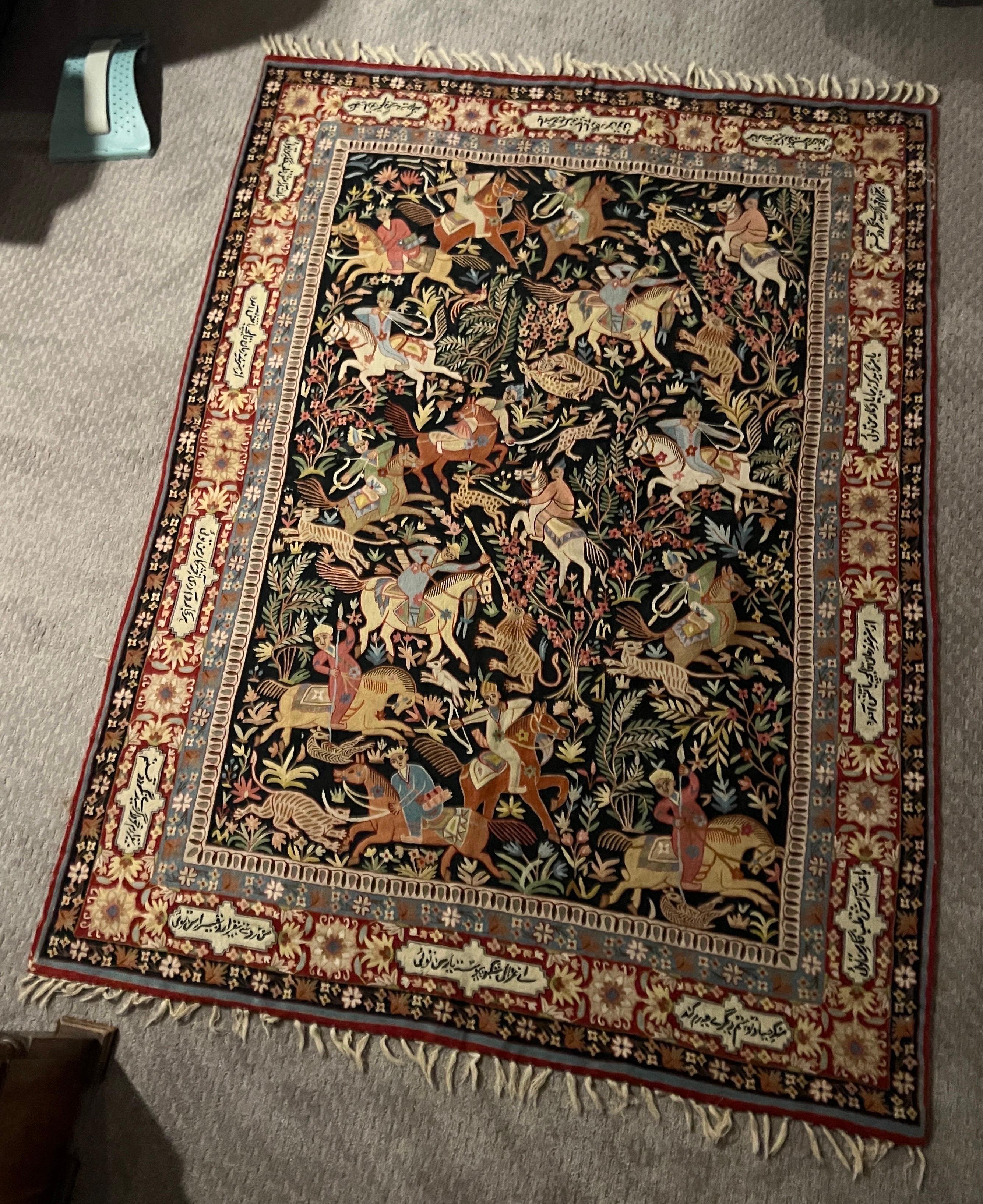 Kashmiri, 20th century.

A vintage hand woven wool tapestry rug - Qum pattern. Depicting figural hunting scene motifs to center and written scene to border. Roughly 4' 11