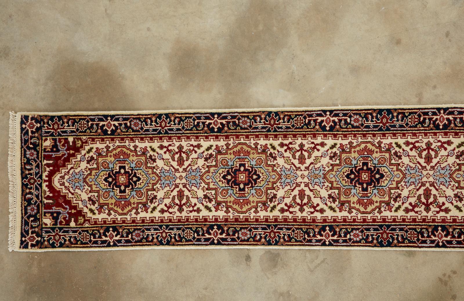 Dramatic long Indo Persian Serapi design runner rug over 15 feet. Features seven geometrical medallions over a beige field with a distinctive black border. Interesting light blue accents with light and dark green highlights. The hand knotted wool