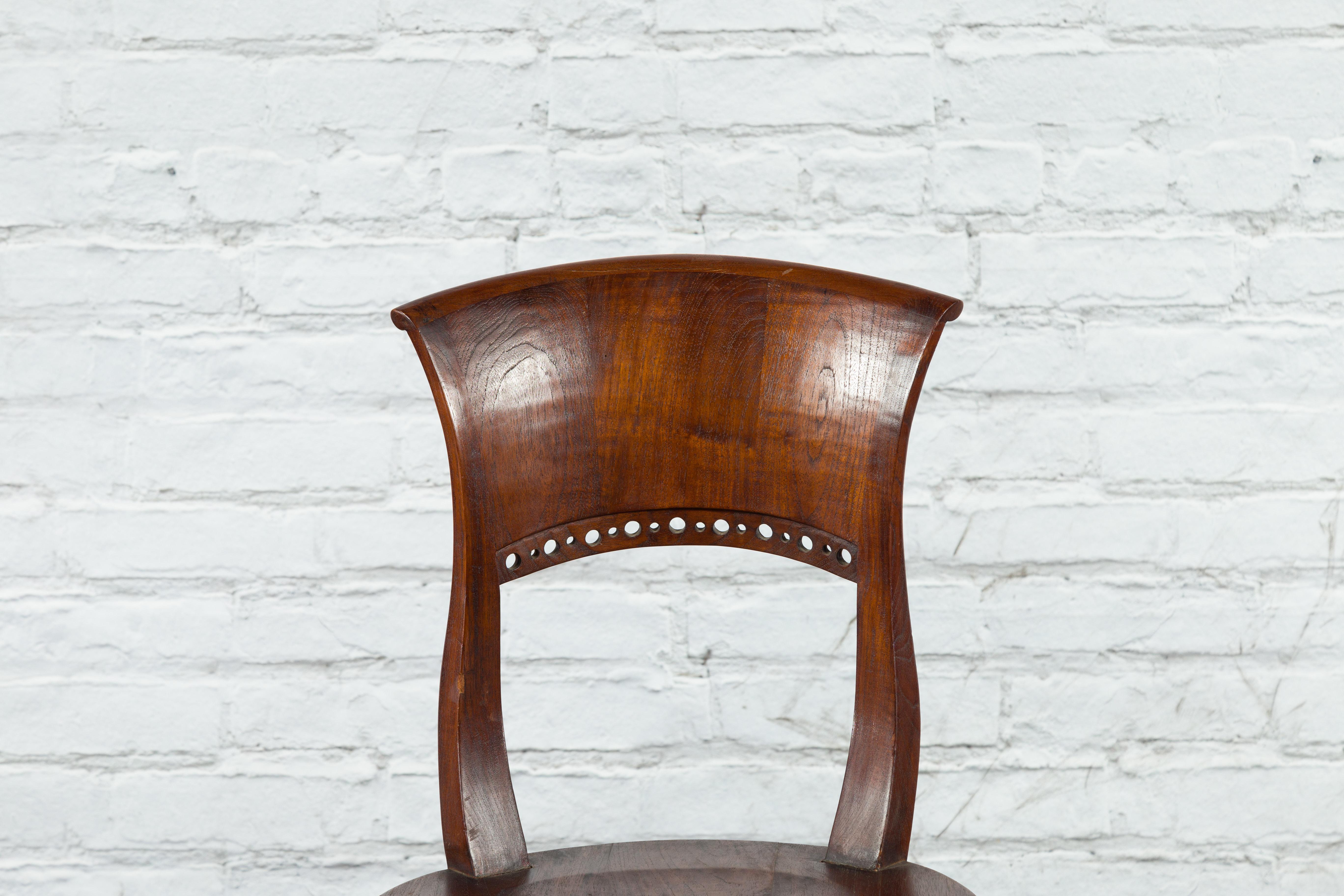 Indonesiano Sedia da salotto vintage in legno dell'Indonesia con motivi circolari traforati e schienale curvo