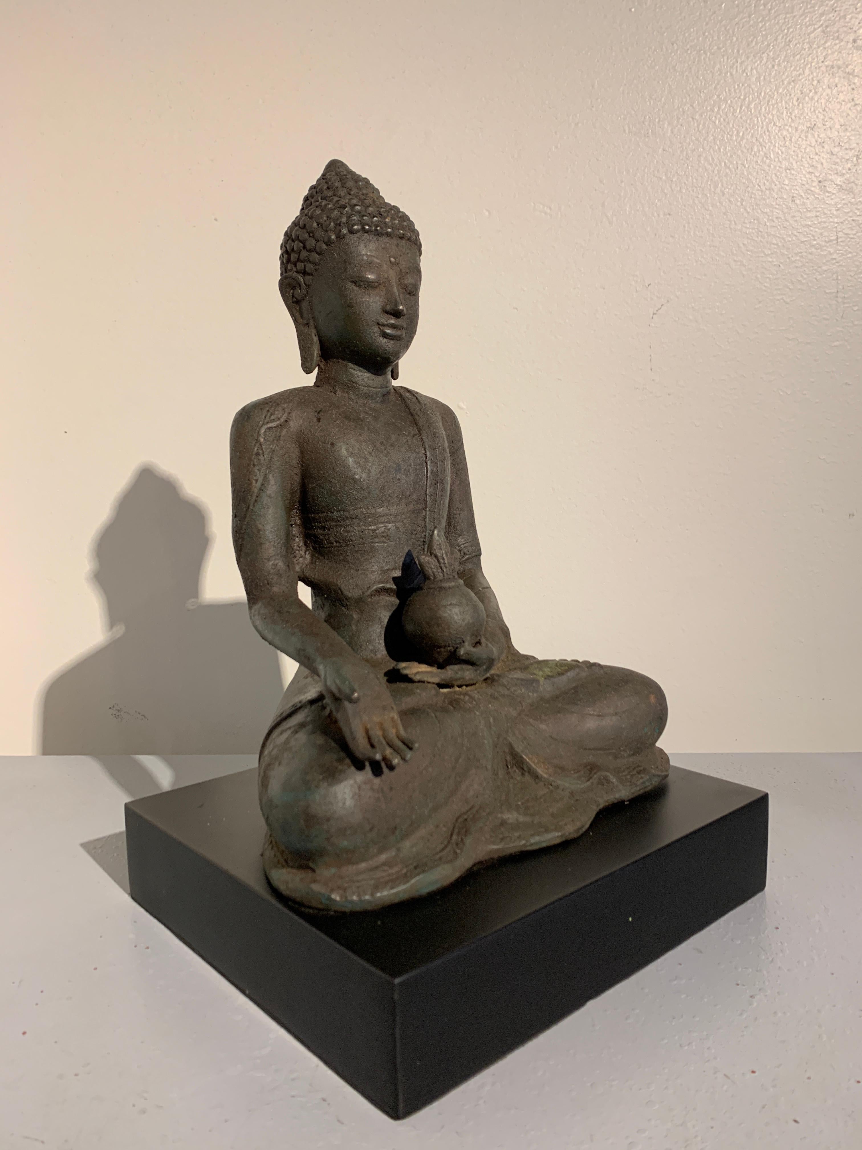 A beautiful and serene vintage cast metal statue of the Medicine Buddha, Bhaisajyaguru, Bali, Indonesia, 1970s.

The Medicine Buddha is simply cast, without excessive details. The Buddha wears a loose robe, with one shoulder and the chest exposed.