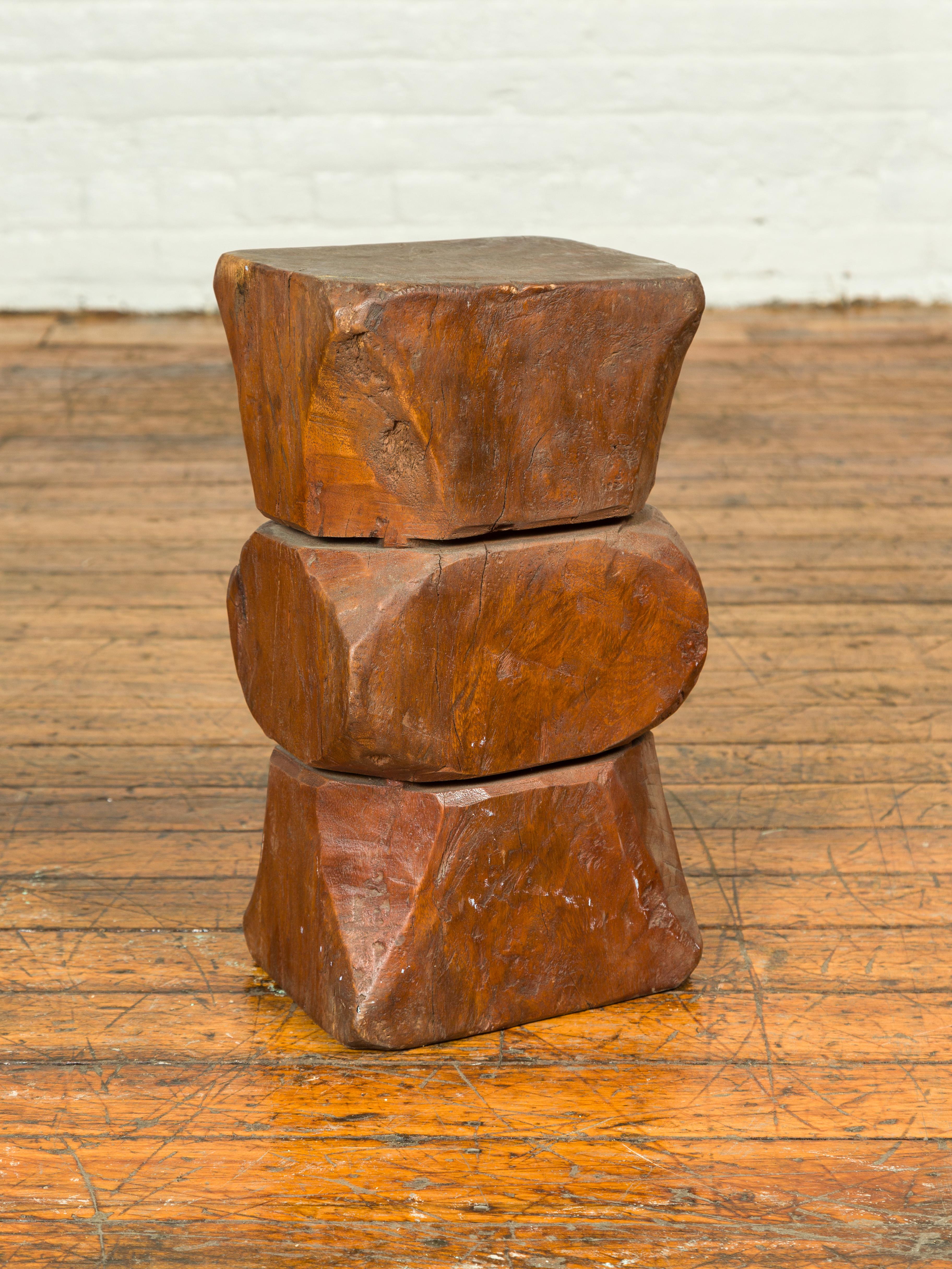 A vintage Indonesian rustic tree stump pedestal from the mid-20th century, with hourglass shape. Crafted in Indonesia, this pedestal will charm you with its rustic appeal and interesting shape. Made of a tree stump roughly carved into geometrical