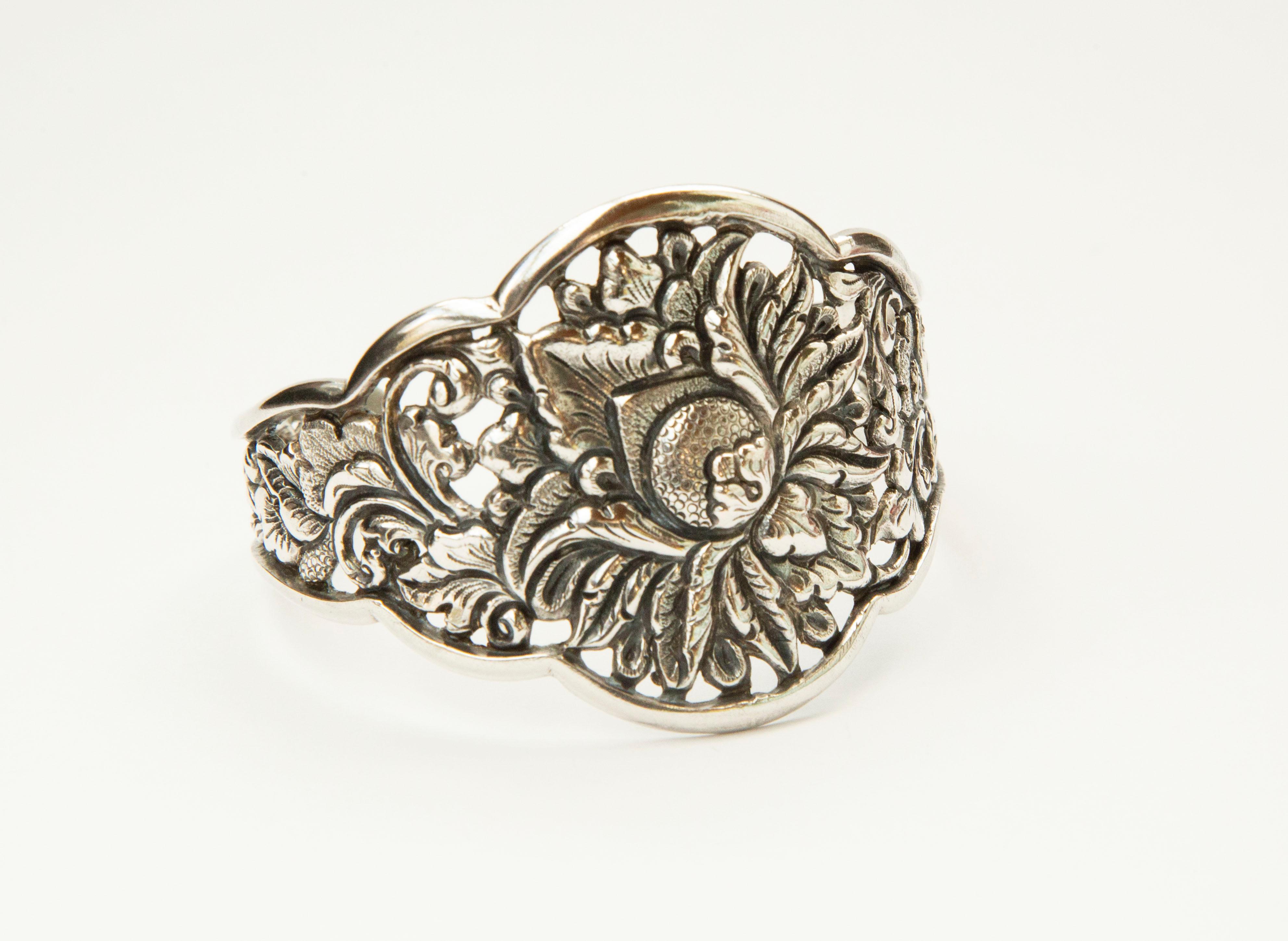 A vintage Indonesian silver 800 cuff bracelet hand made in Java in CA. 1930s. The bracelet features a floral decor that is characteristic for old Indonesian jewelry. The bracelet is marked with the initials of the maker (PK) as well as the silver