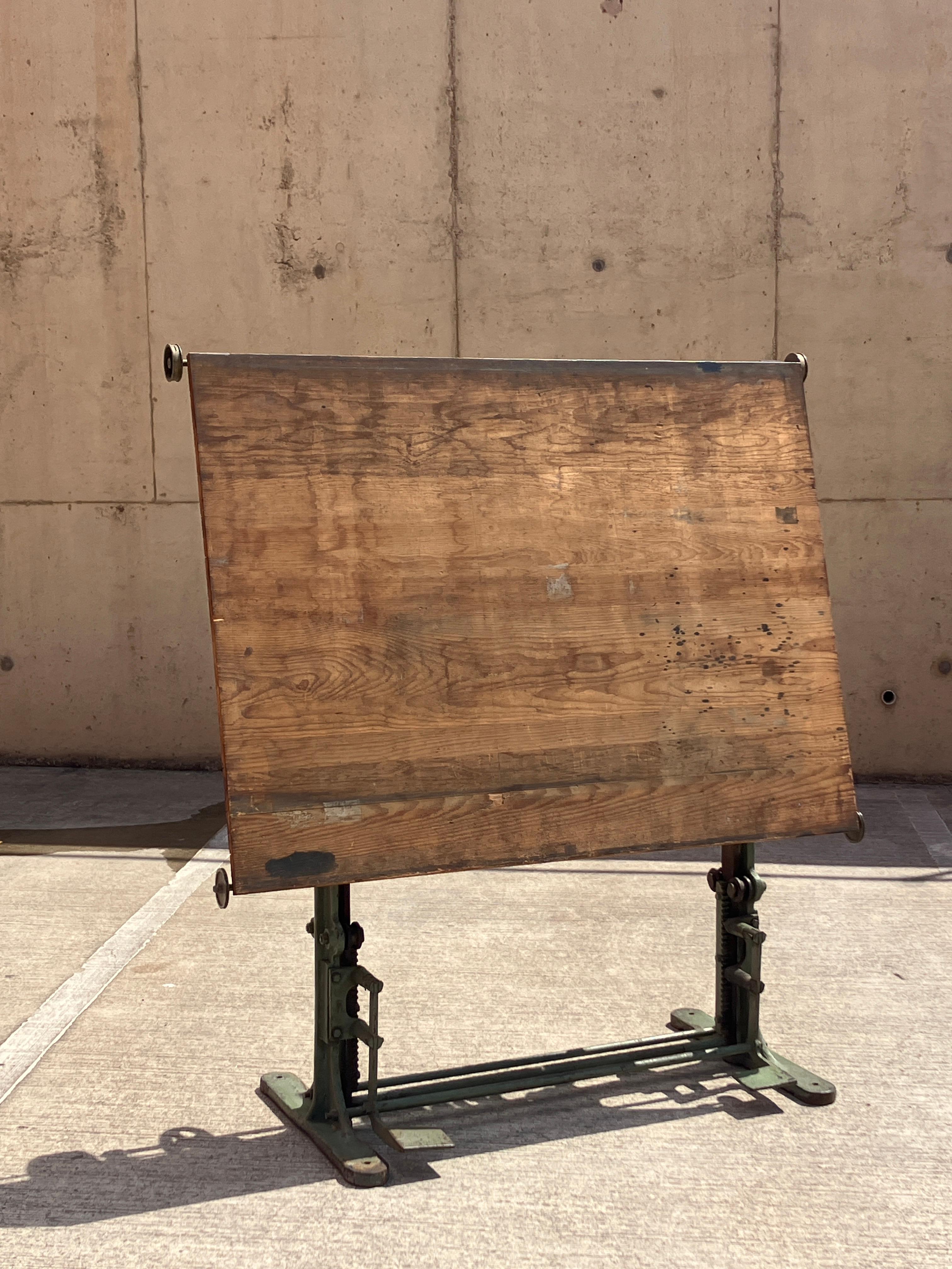 An impressive 1920's cast iron drafting table by Stanley London. Made in England.  An iconic true vintage 'architect's table'; this drafting table is sold as a tall standing desk. Ideal for two people working on each side. The base is a very heavy