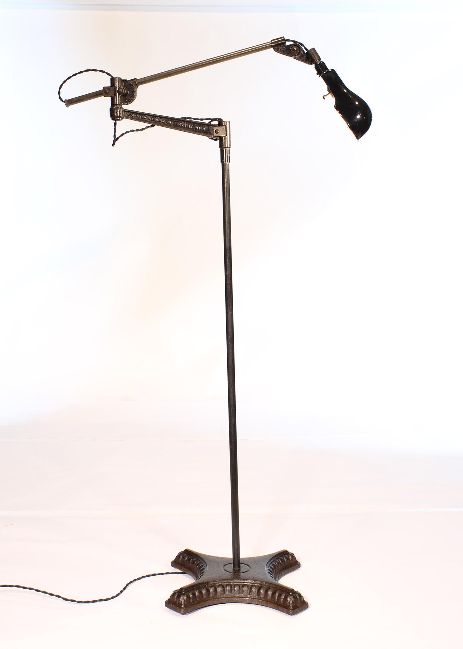 Authentic vintage industrial adjustable Woodward cast iron and steel floor lamp / reading light. Lamp is fully adjustable, with a swivel top, and can be formed into a variety of positions. Overall height is adjustable from 55 1/2