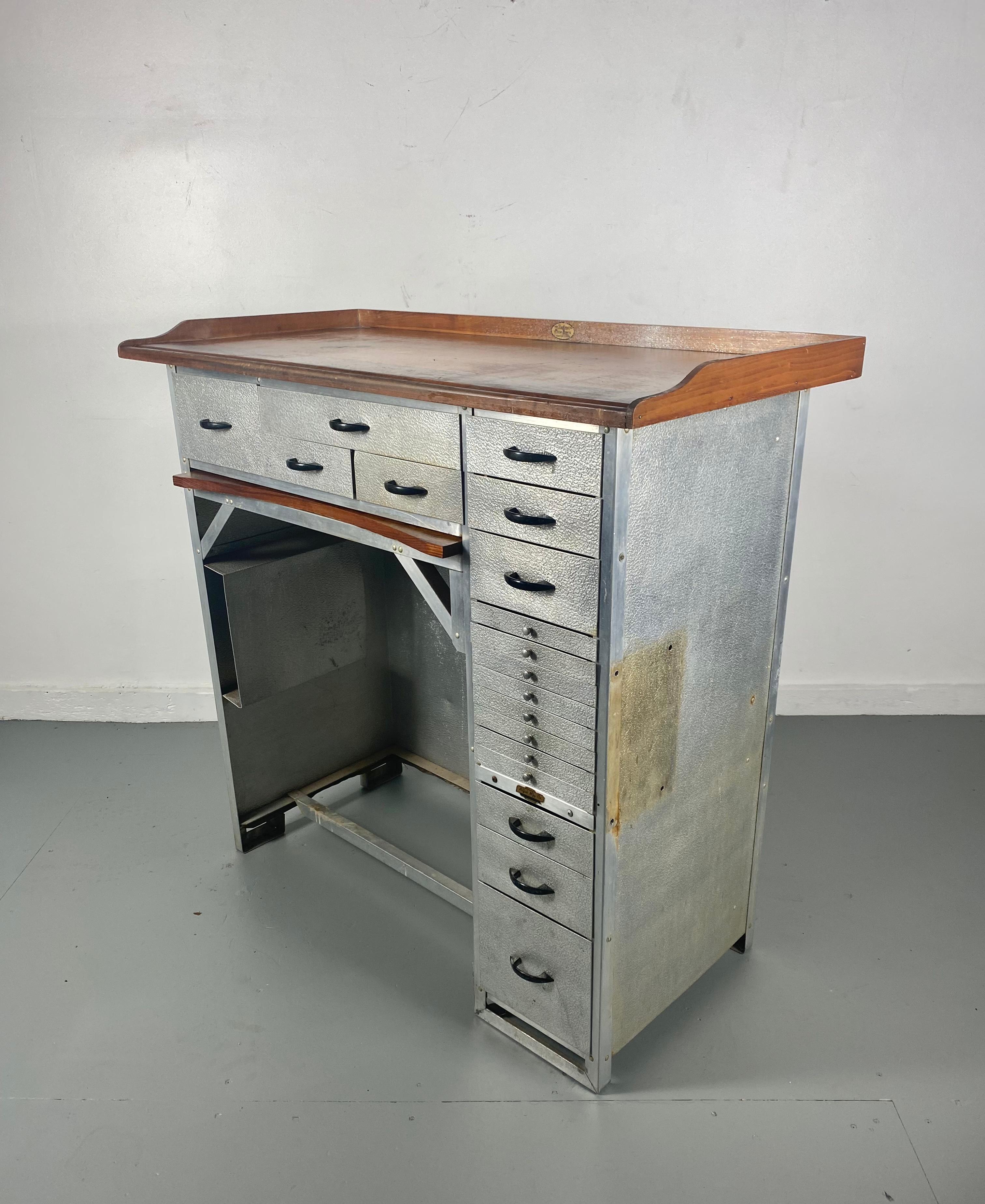 Impressive aluminum desk with numerous drawers used originally for watch making. made by ALFAB.. (aluminum fabricating),, Finished wood top, hammered aluminum, original bakelite handles.Pull out catch tray,, Makes a great kitchen prep table as well
