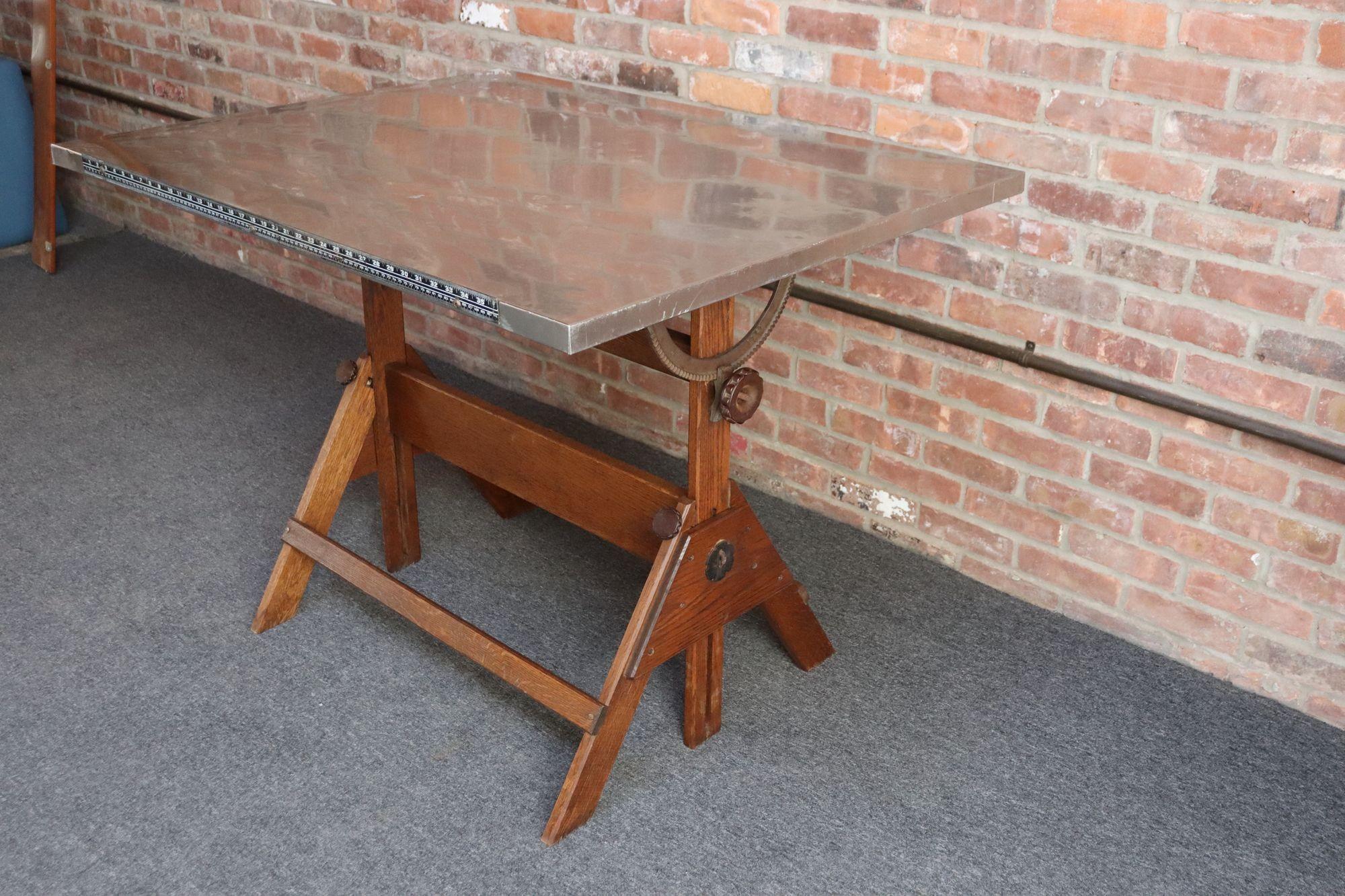 Table à dessin industrielle en chêne avec surface en acier, entièrement réglable grâce à des charnières, des boutons et des supports en fonte, fabriquée par Anco Bilt de Glendale, New York (vers les années 1940).
La surface peut être facilement