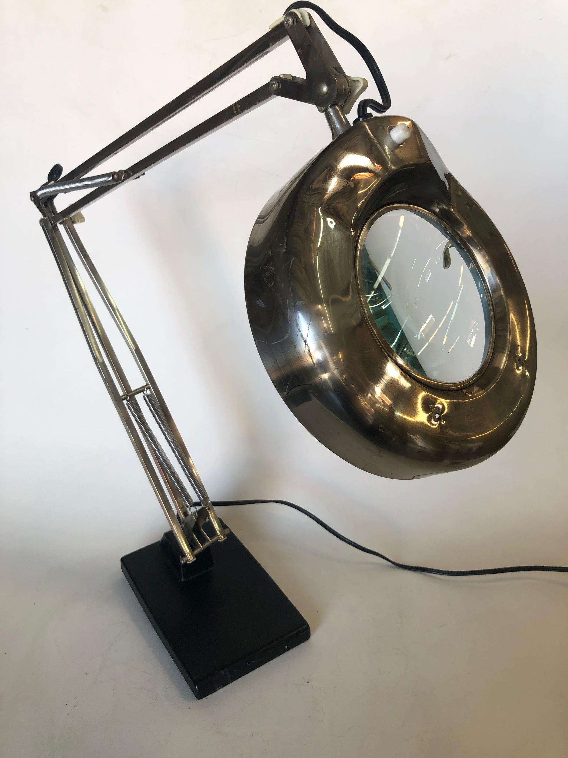 Vintage articulating floating fixture magnifying dazor desk lamp with weighted base.

Takes 22 Watt circular bulb. 

Measures 30