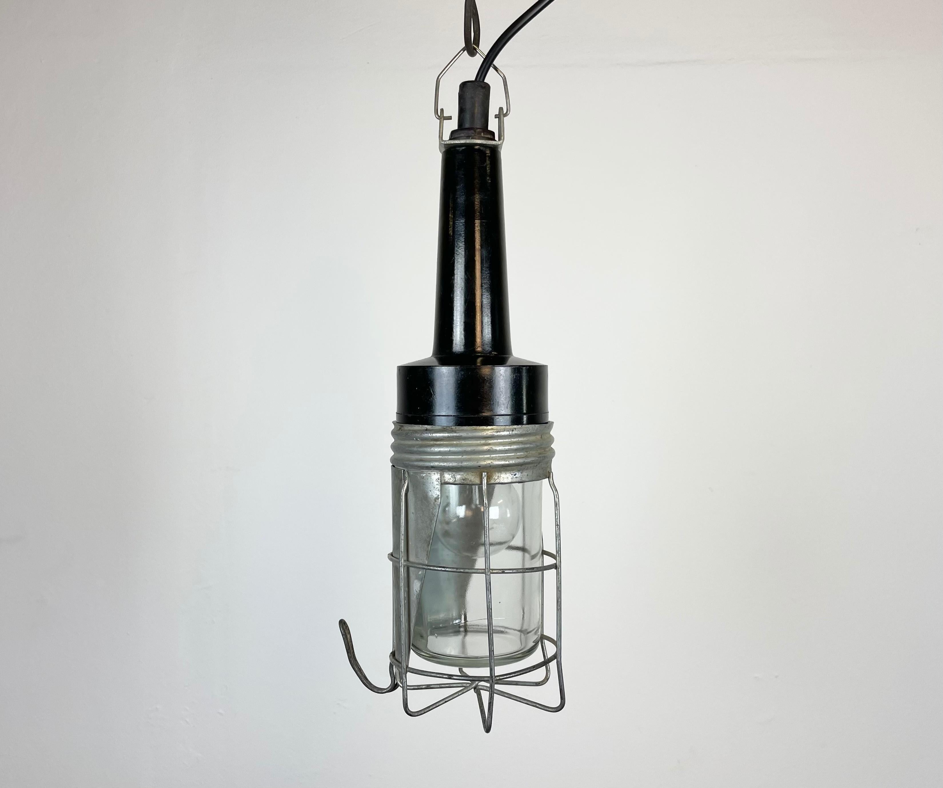 Industrial walkabout work lamp made in former Czechoslovakia during the 1960s These lamps were used in factories, workshops and army as a portable light source . It features a bakelite handle, an iron grid and clear glass cover.
The socket requires