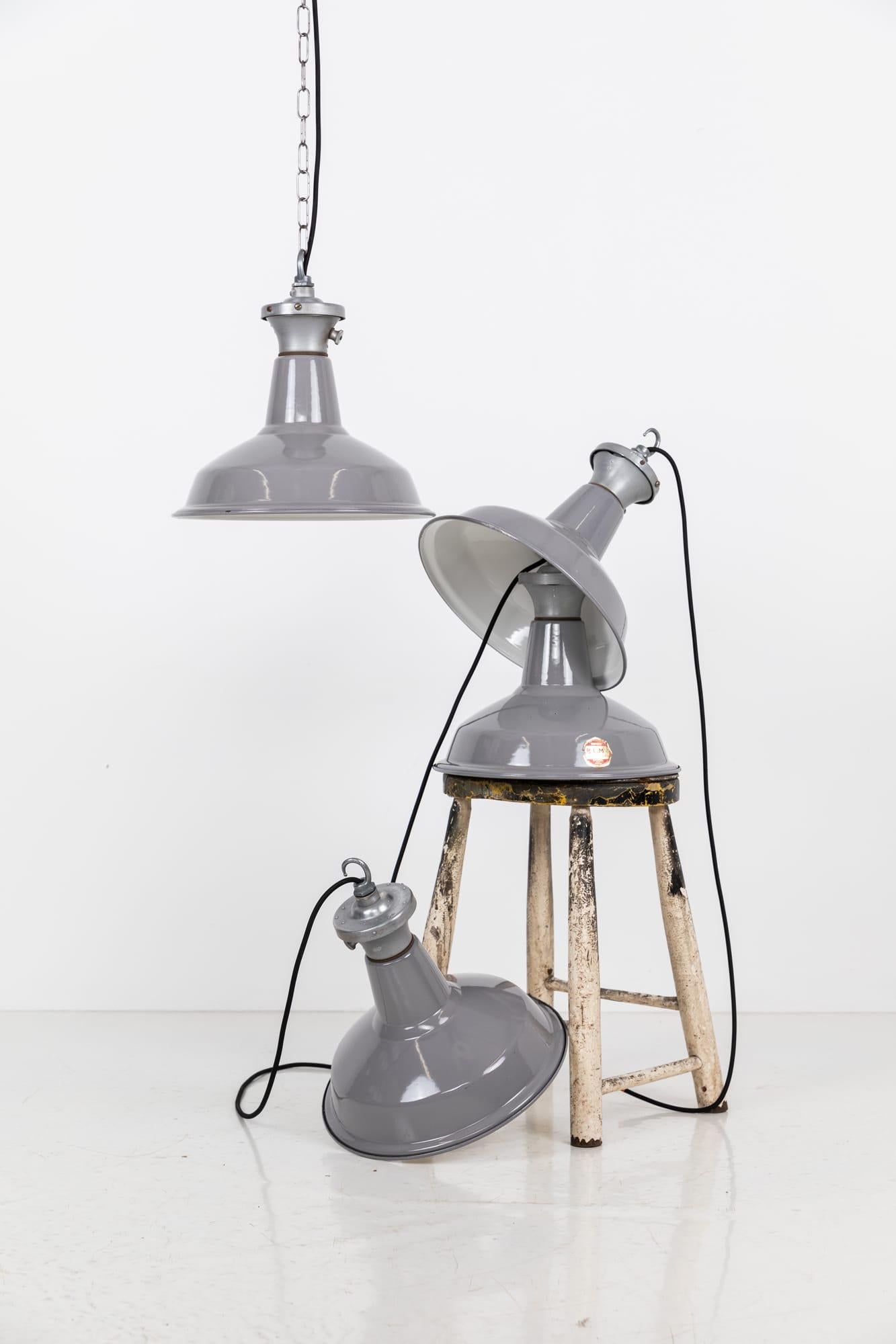 

Grey vitreous enameled pendant lights by renowned industrial manufactures Benjamin Electric. c.1930

In a smaller size than usually seen, surviving in amazing original condition, with very little wear to the enamel and remnants of the paper labels