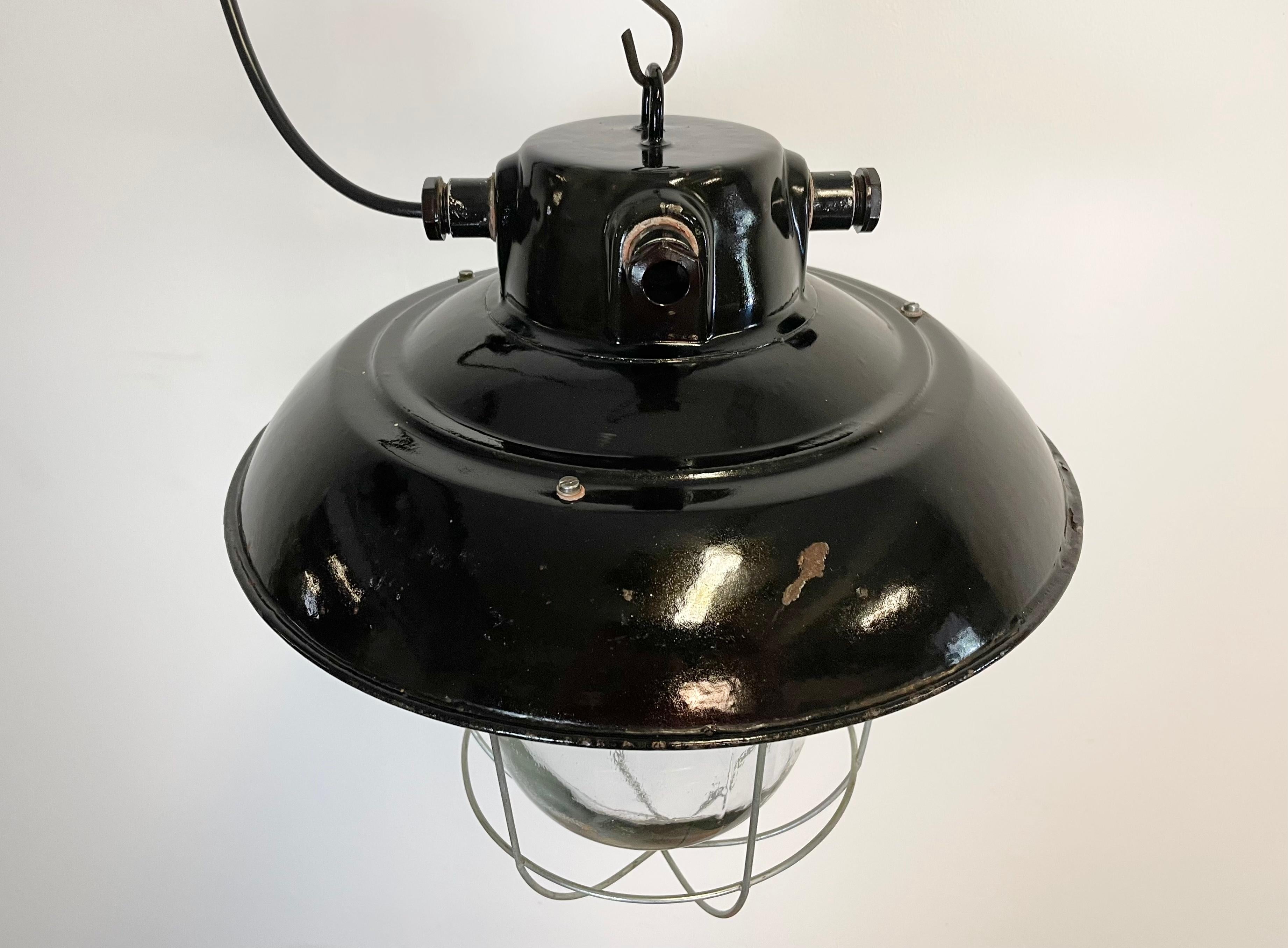 - Vintage Industrial lamp from former Czechoslovakia made during the 1960s
- Black enamel shade with white interior
- Frosted glass, Iron grid
- New porcelain socket for E 27 lightbulbs and wire
- Weight: 4 kg
- Fully functional.