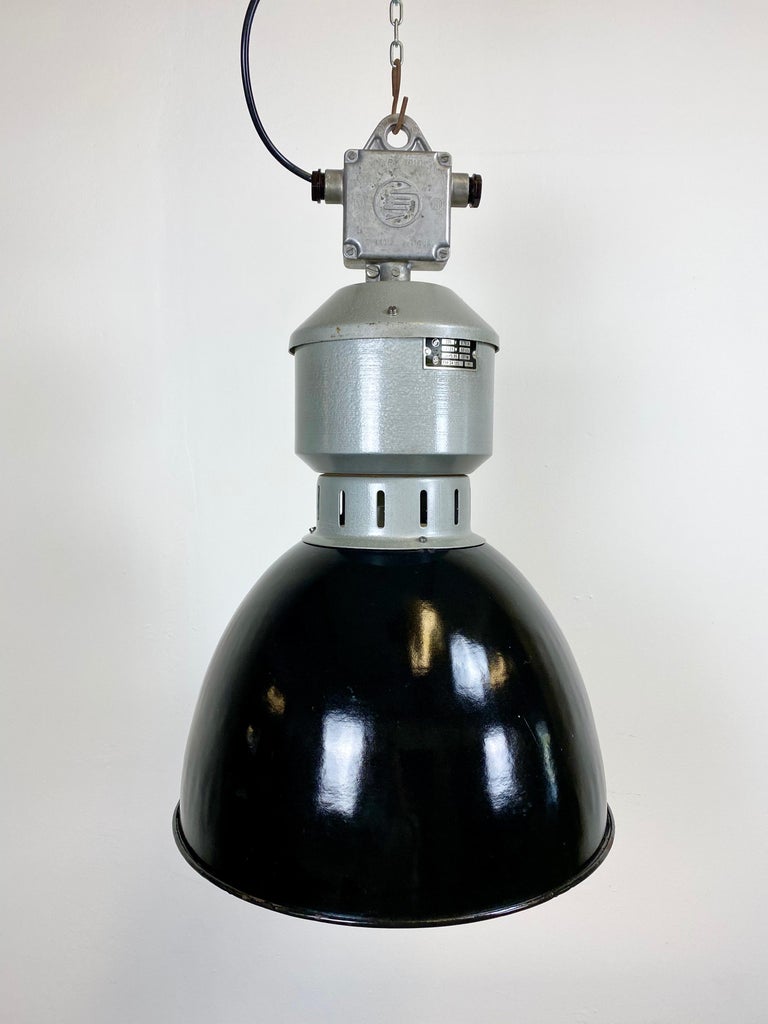 - Industrial hanging light from the 1960s
- Manufactured by Elektrosvit in former Czechoslovakia
- Black enamel shade with white interior
- Cast aluminum top
- New E 27 fitting and wire
- The weight of the lamp is 3.5 kg.