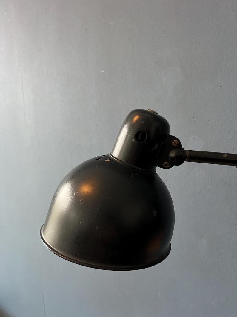 Applique noire à ciseaux avec abat-jour et cadre réglables. La lampe s'étire et se plie facilement grâce au mécanisme de ciseaux extensible. L'abat-jour lui-même peut également monter et descendre. La lampe nécessite une ampoule E27/26 (standard) et