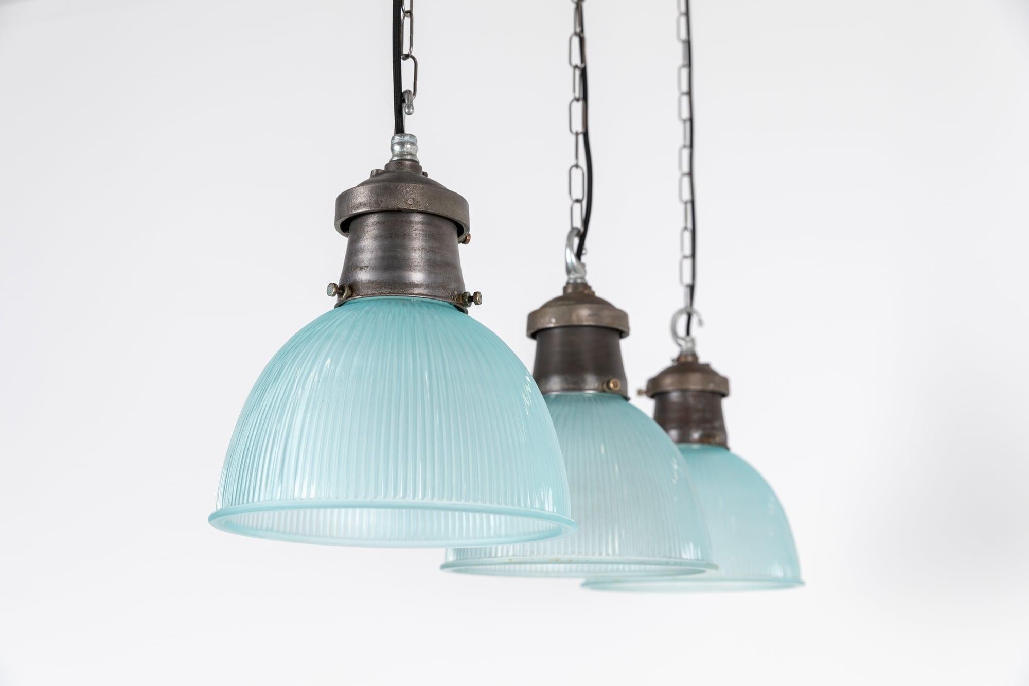 40 available!

An incredible run of scarcely found blue tinted pendants made in England by Holophane. c.1930

Beauitful crisp prismatic glass reflectors and original industrial cast galleries, both bearing the Holophane makers mark. Salvaged from a