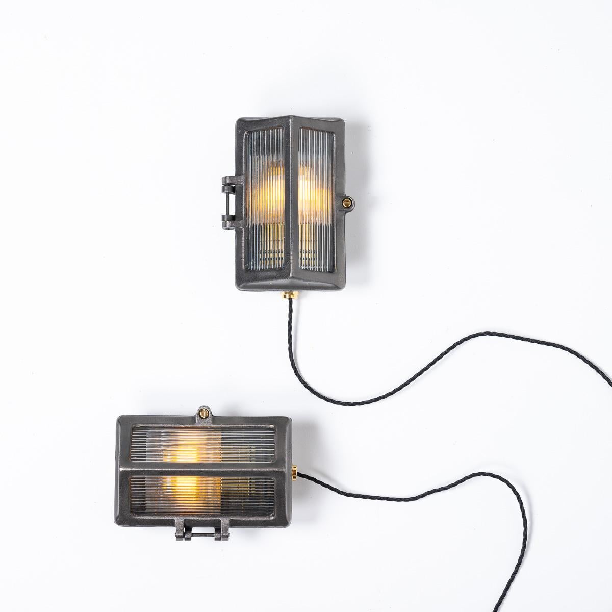 RECLAIMED  INDUSTRIAL BULKHEAD LIGHT FITTINGS WITH REEDED GLASS

Featured in the Everything Electrical Catalog by maker The General Electric Co Ltd.

Model number F64018 produced between 1940 and 1960.

Two angled heavy reeded glass windows offer a