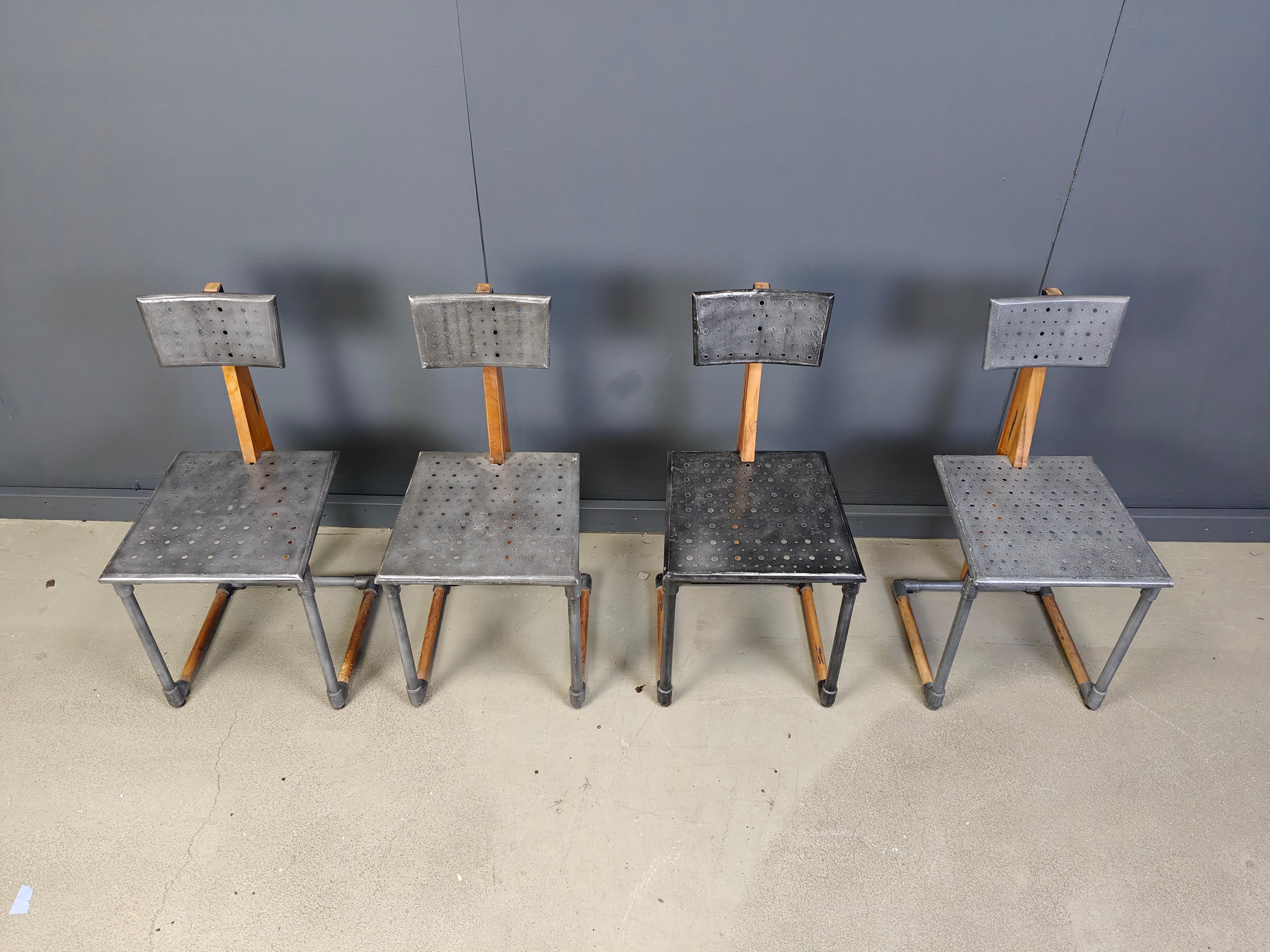 Ensemble de chaises de salle à manger industrielles rares, constituées d'une structure en métal et en bois, avec des sièges et des dossiers en métal perforé.

Très robuste et d'un style industriel très cool.

Dessinateur inconnu, peut-être un