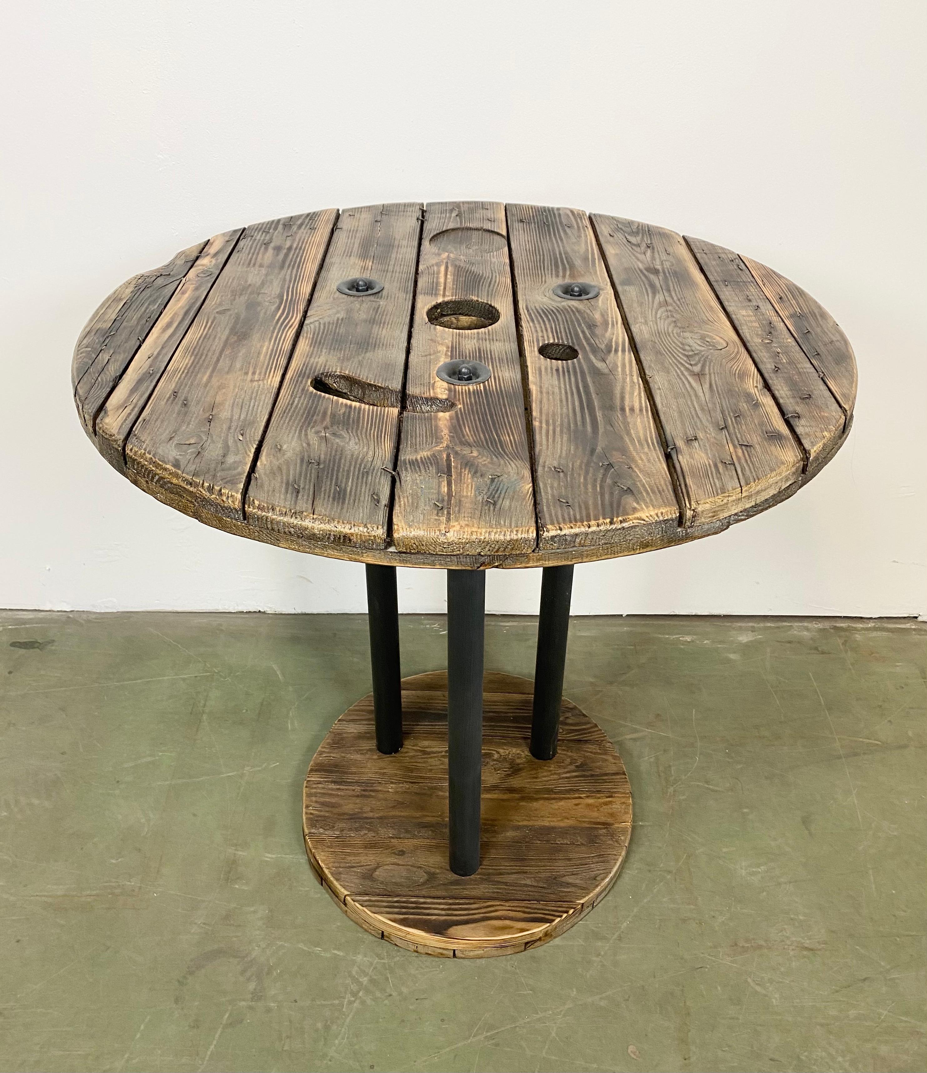 Vintage Industrial circle coffee table from the 1960s. It features black iron legs and a solid wooden plates with very nice patina. Weight: 24 kg. Additional information: Diameter of the plates: Upper 80 cm, bottom 50cm. The price for transport is