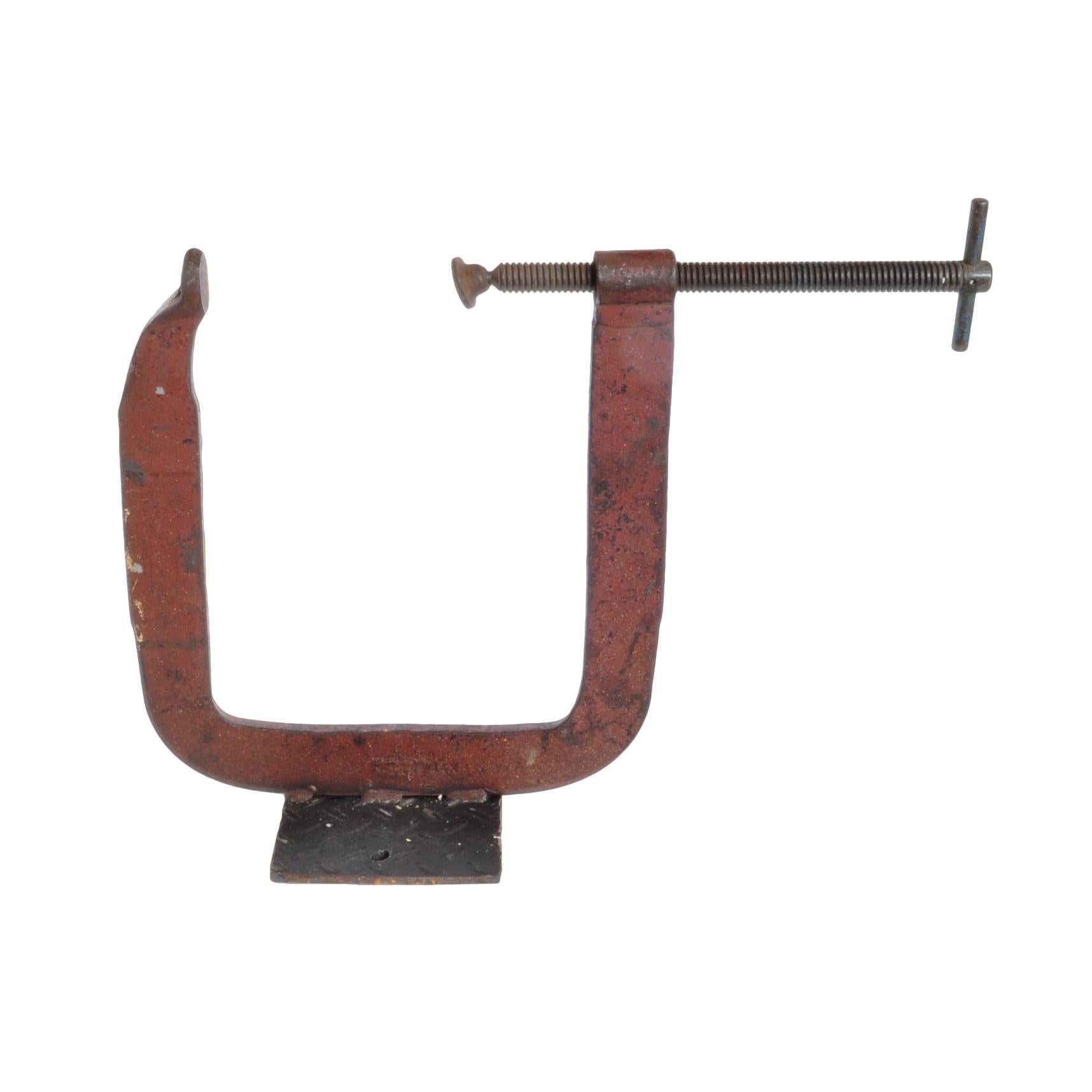 Introducing a stunning industrial C-shaped clamp, expertly welded to a durable steel base. This unique piece is not only functional but also a charming addition to your home decor. With its rustic appeal, it's sure to add a touch of character and