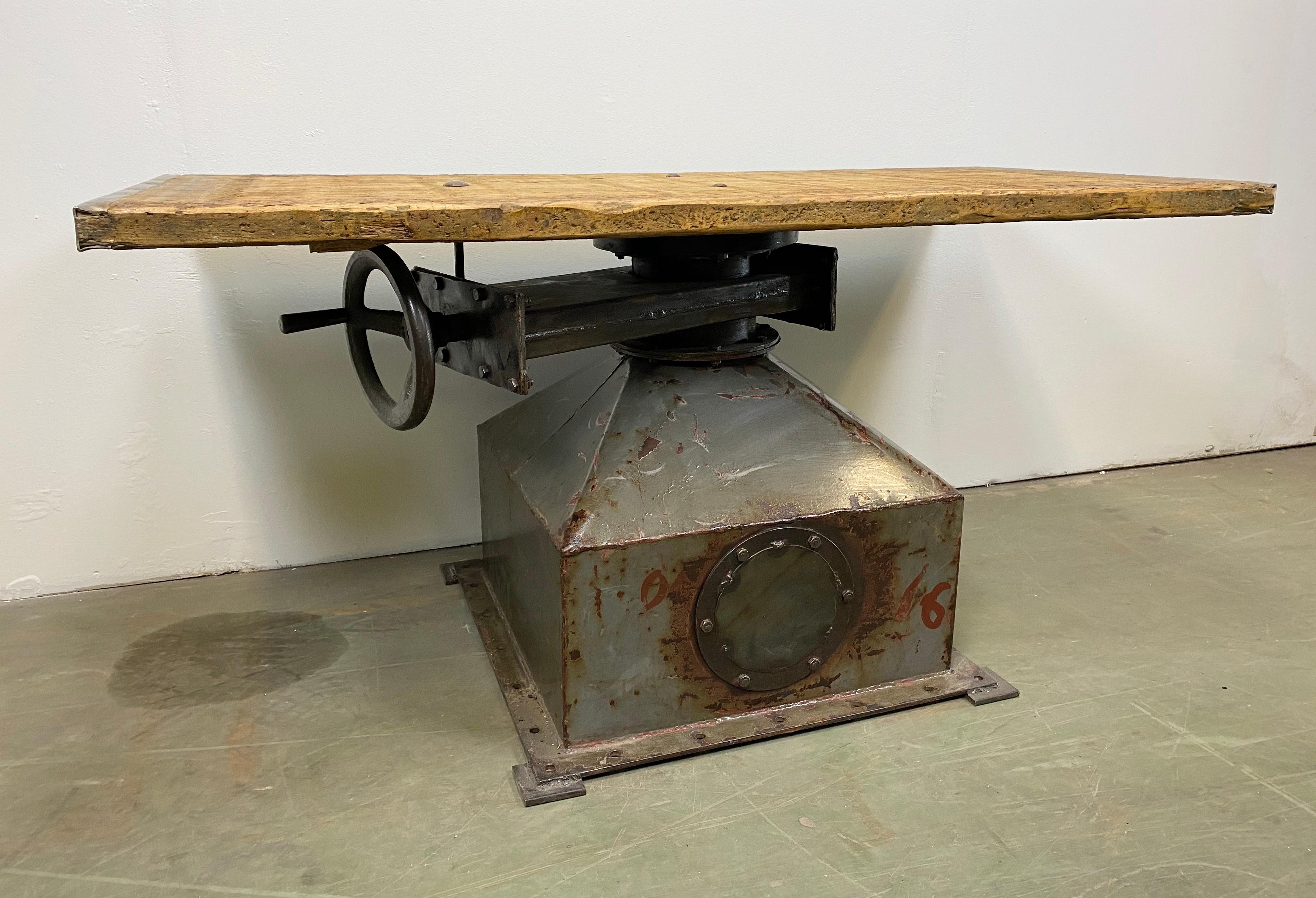 Vintage industrial coffee table from the 1950s. It features iron construction and a solid old wooden plate with very nice patina. Weight: 70 kg.