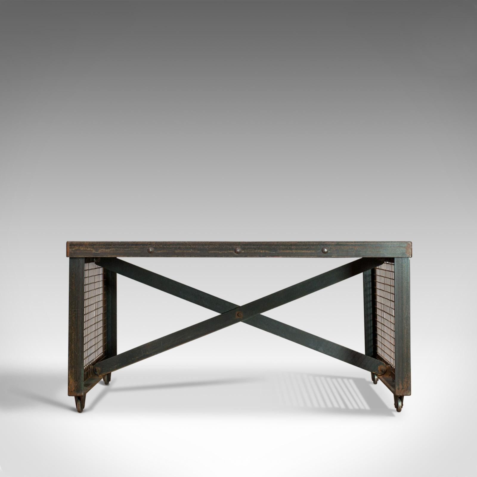 This is a vintage industrial coffee table. An English, steel and oak table dating to the 20th century.

Strong industrial taste with a desirable aged patina
Select cuts of weathered oak display a fine grain interest
Exposed welds at each corner